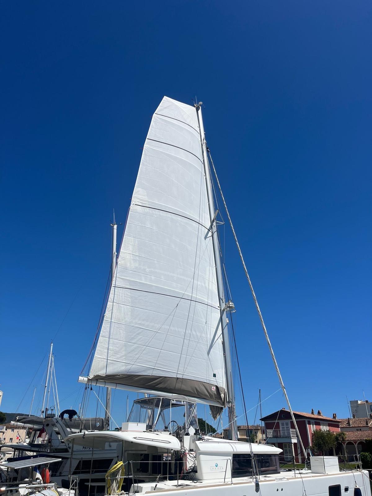Sailing yacht Lagoon 450 F, 2016 model, with raised sails against a clear blue sky.