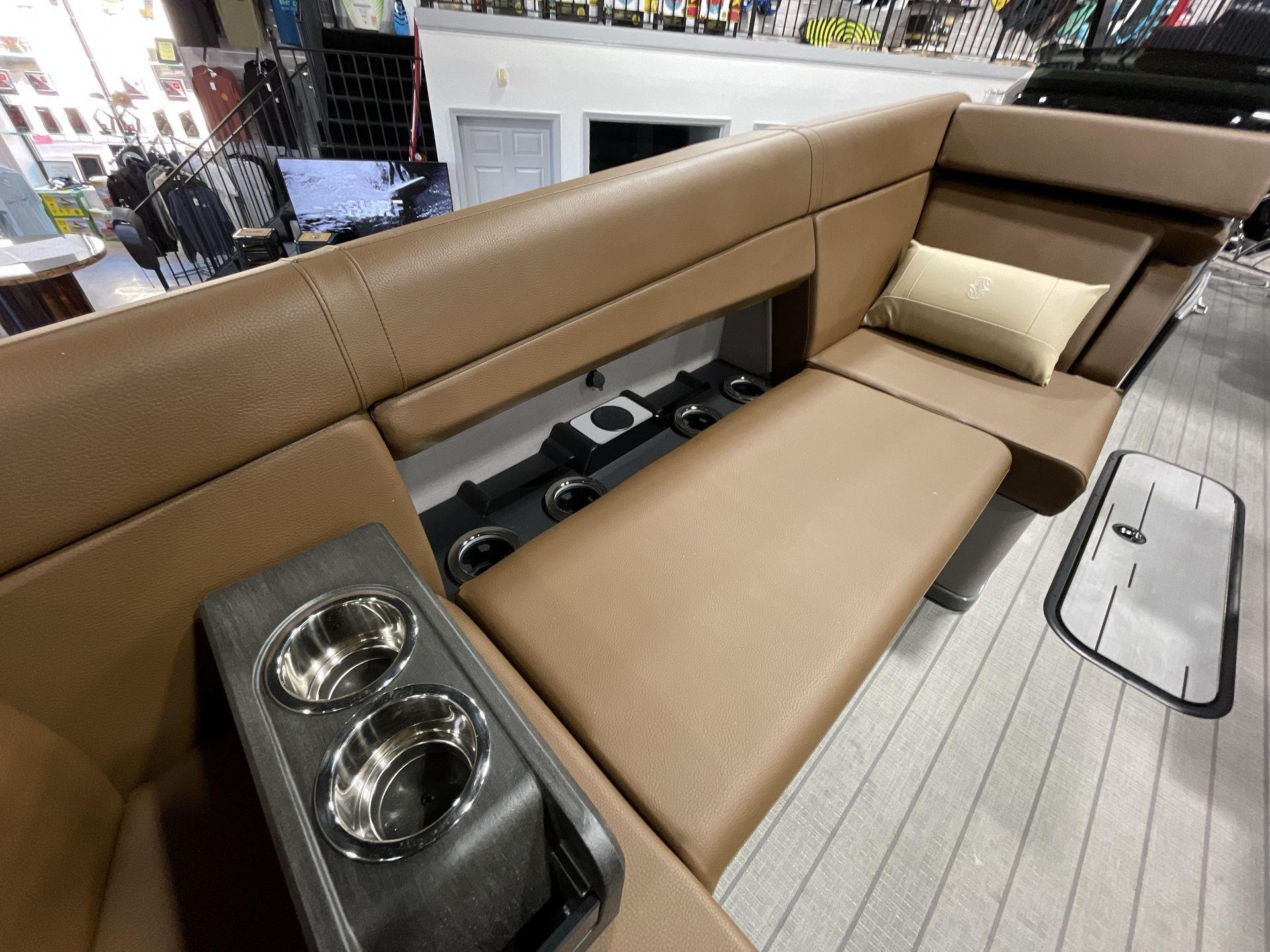 Luxurious seating on 2025 Balise Horizon 26C boat with cup holders and cushion.