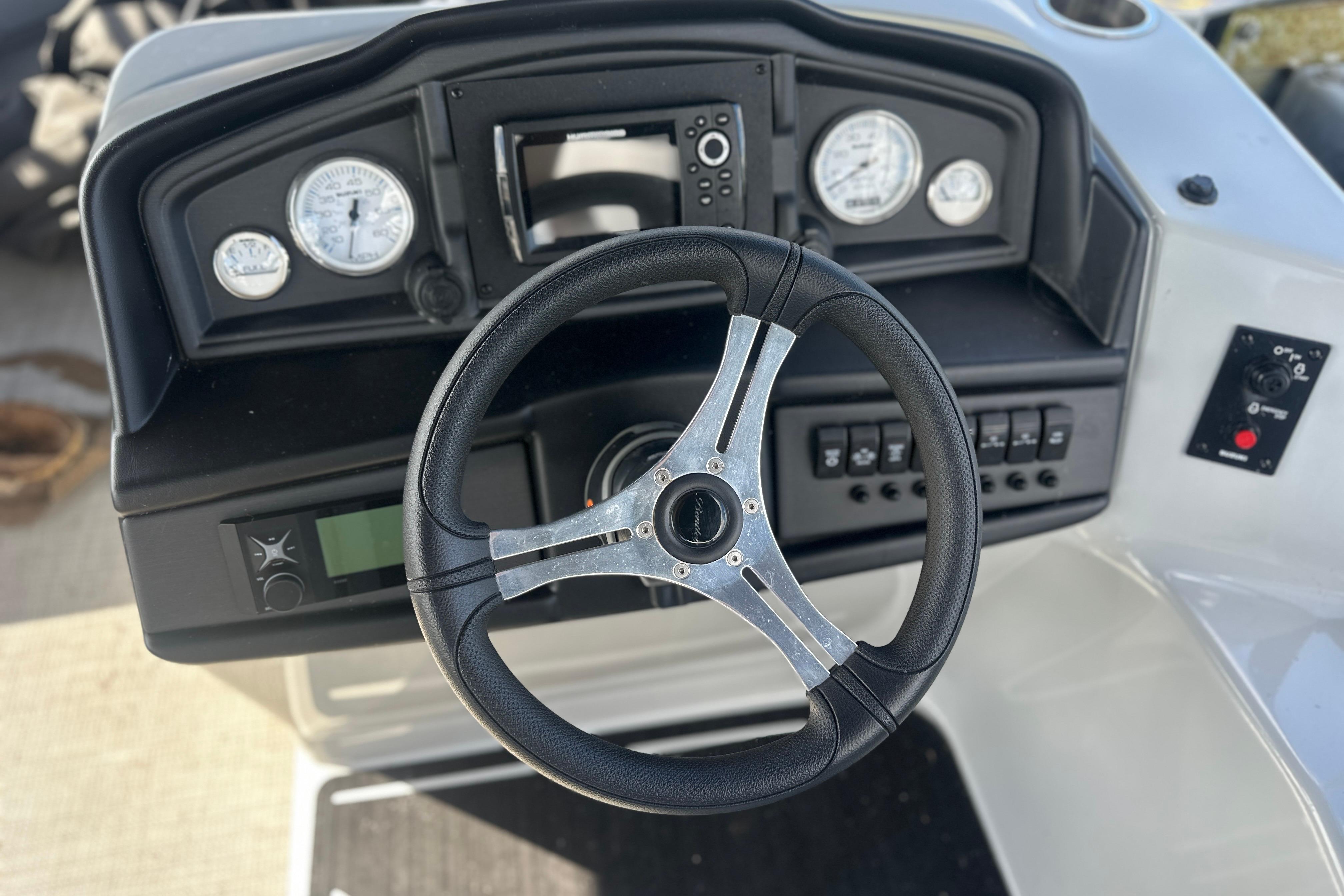 Steering console of 2023 Bentley Pontoons Legacy 243 Swingback with gauges and controls.