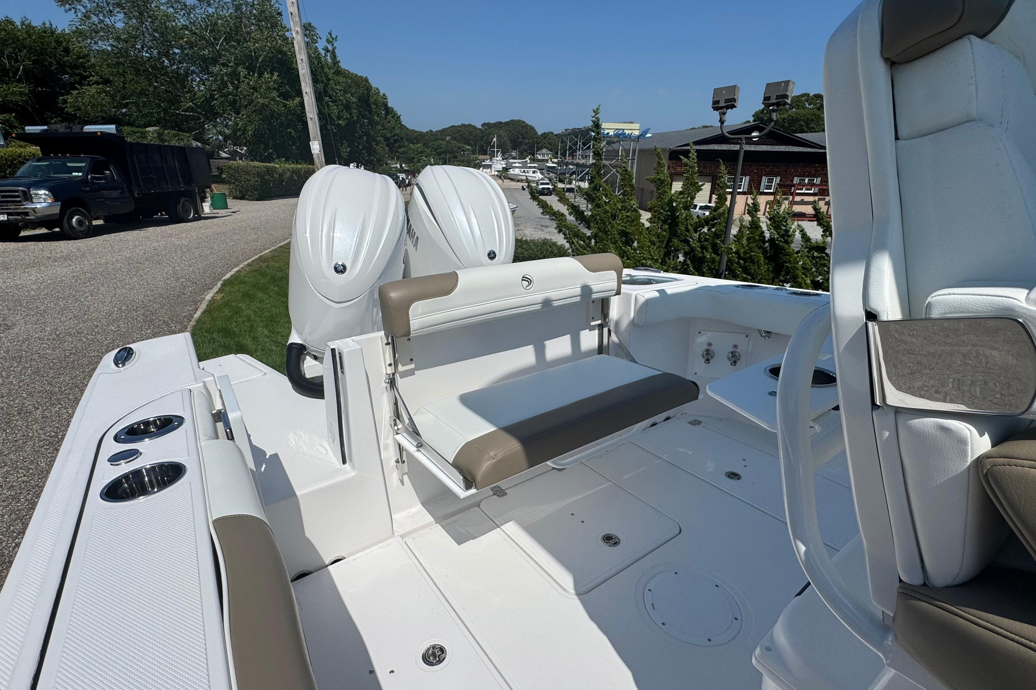 2026 Edgewater 250CC boat with dual engines and seating, parked outdoors.