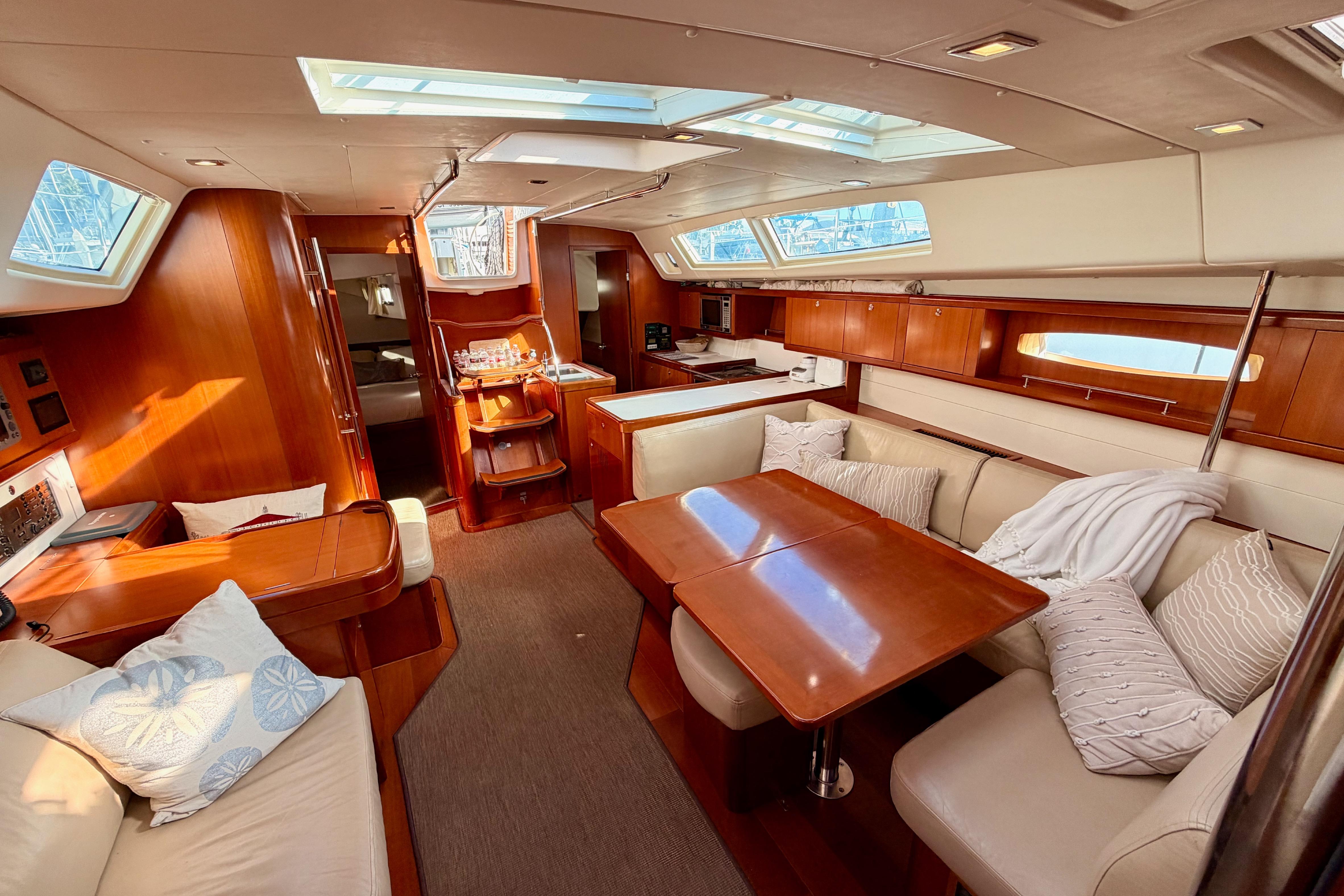 Luxurious interior of 2007 Beneteau 49 yacht with elegant wood finish and plush seating.