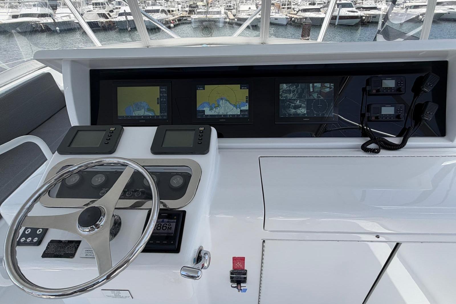 Helm of 2003 Hatteras 54 Convertible yacht with navigation screens and controls.
