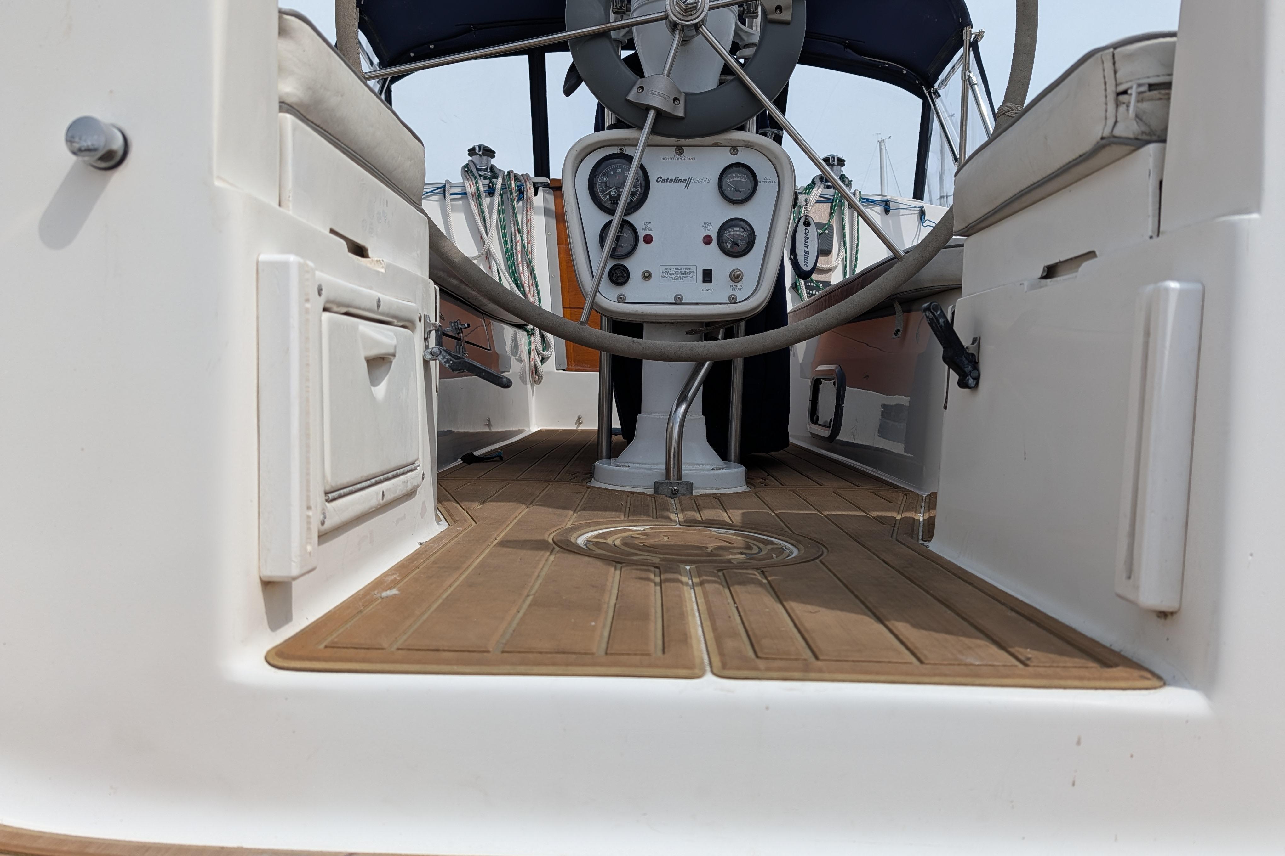 Cockpit view of a 1995 Catalina 36 MkII sailboat with steering wheel and control panel.