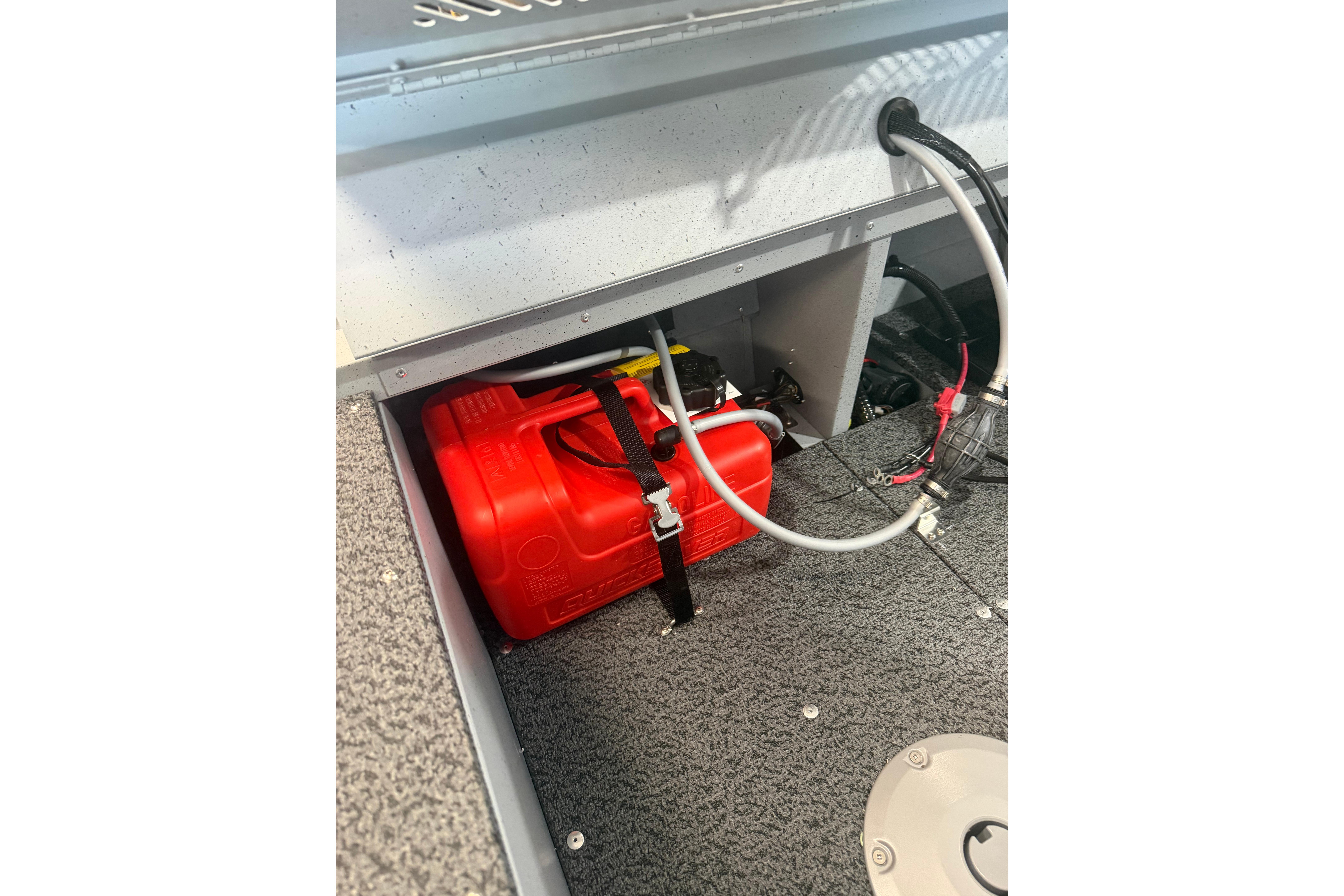 Storage compartment in 2027 Lund 1600 Fury SS boat with red fuel tank and wiring.