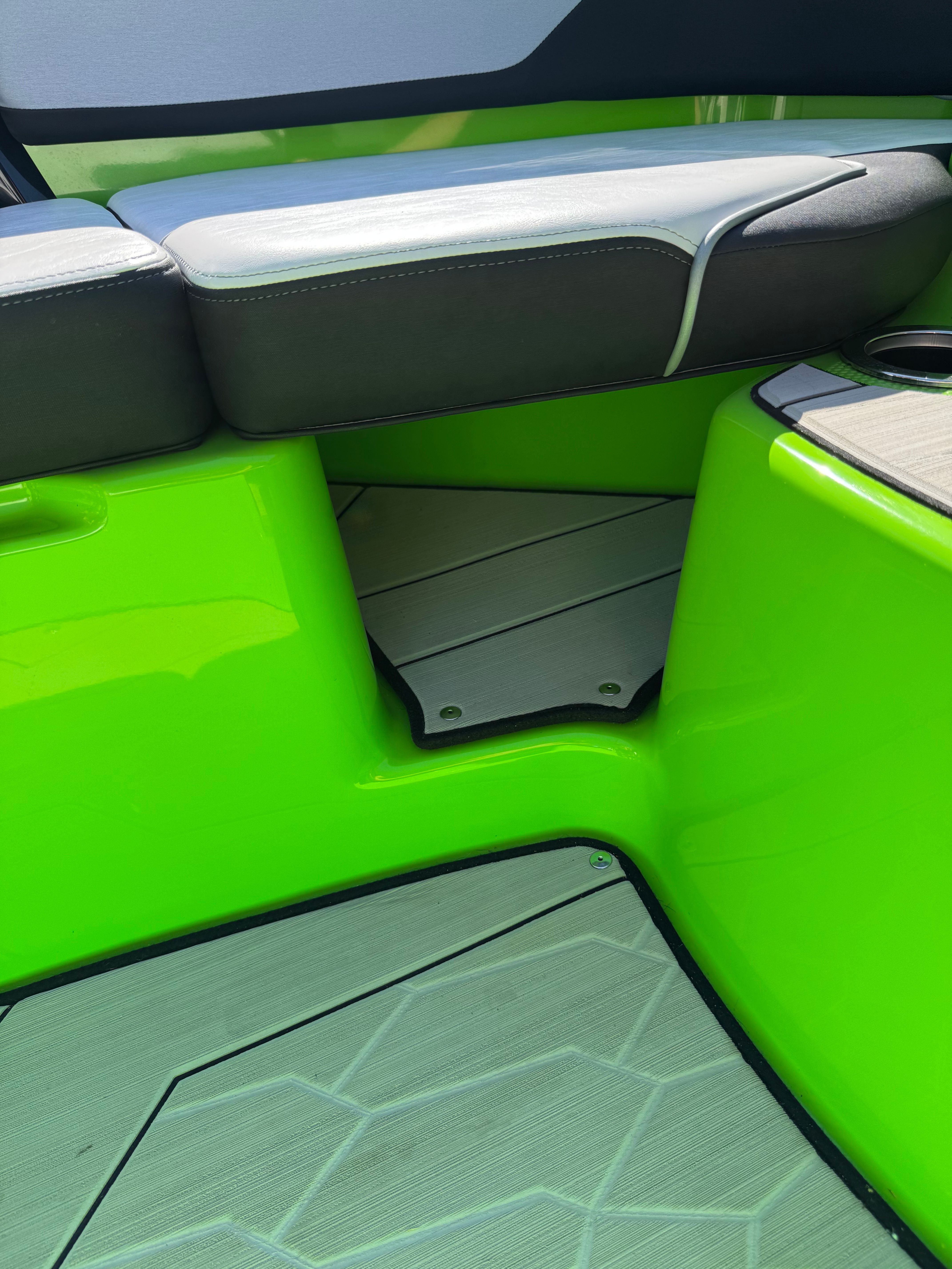 Close-up of a bright green boat floor with gray upholstery.