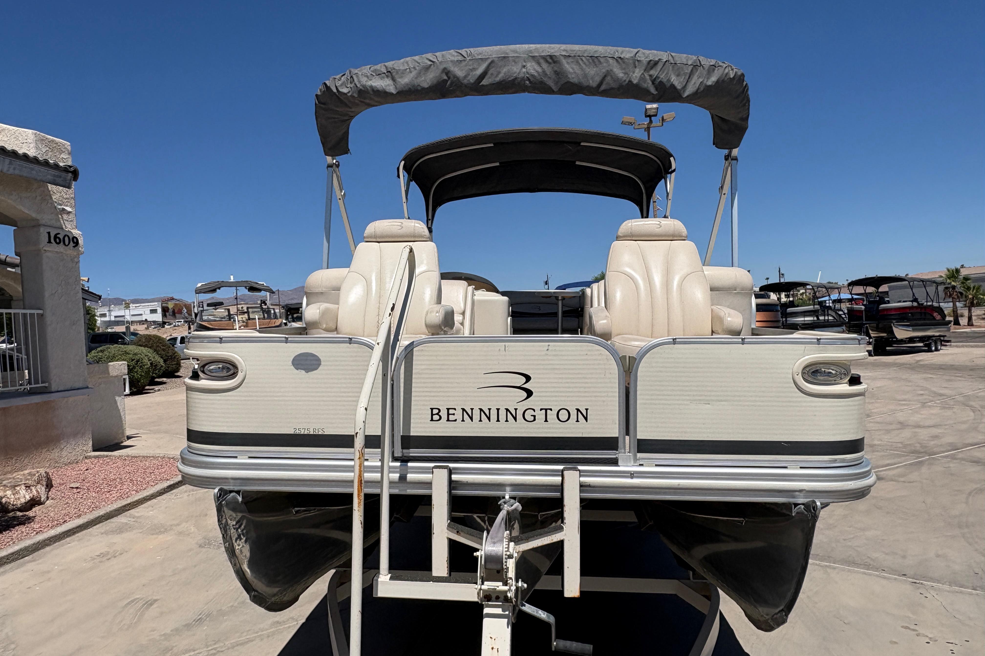 2005 Bennington 2575RFS I/O pontoon boat with canopy, parked on a trailer.