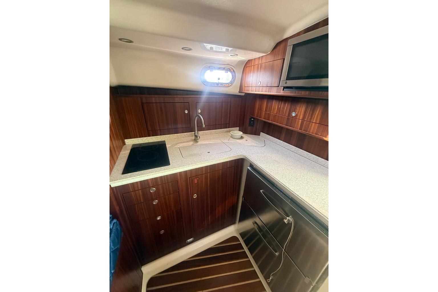 2010 Pursuit OS 375 Offshore yacht kitchen with wood cabinetry and modern appliances.