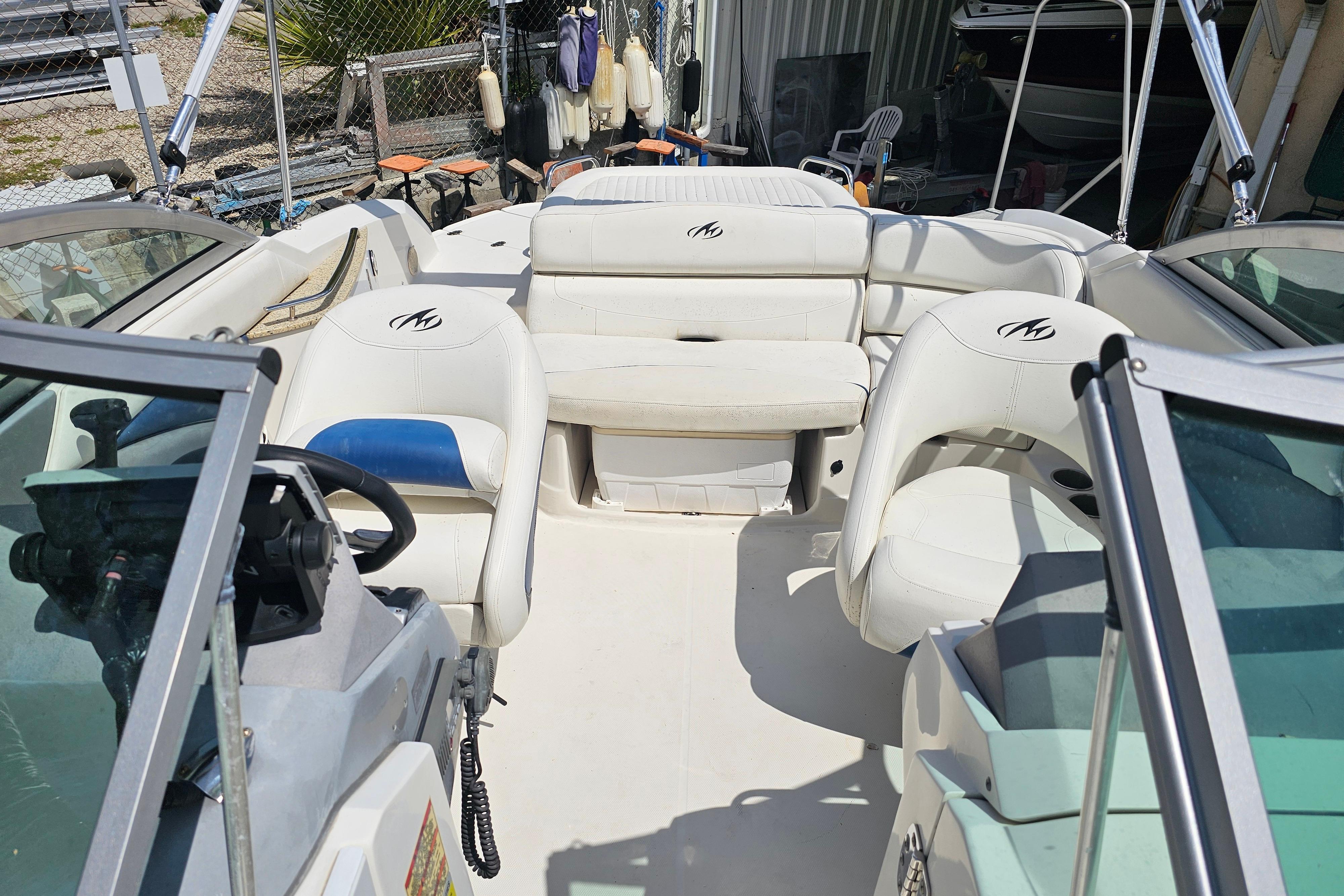 Interior of a 2008 Monterey 220 Explorer boat with white seating and steering wheel.