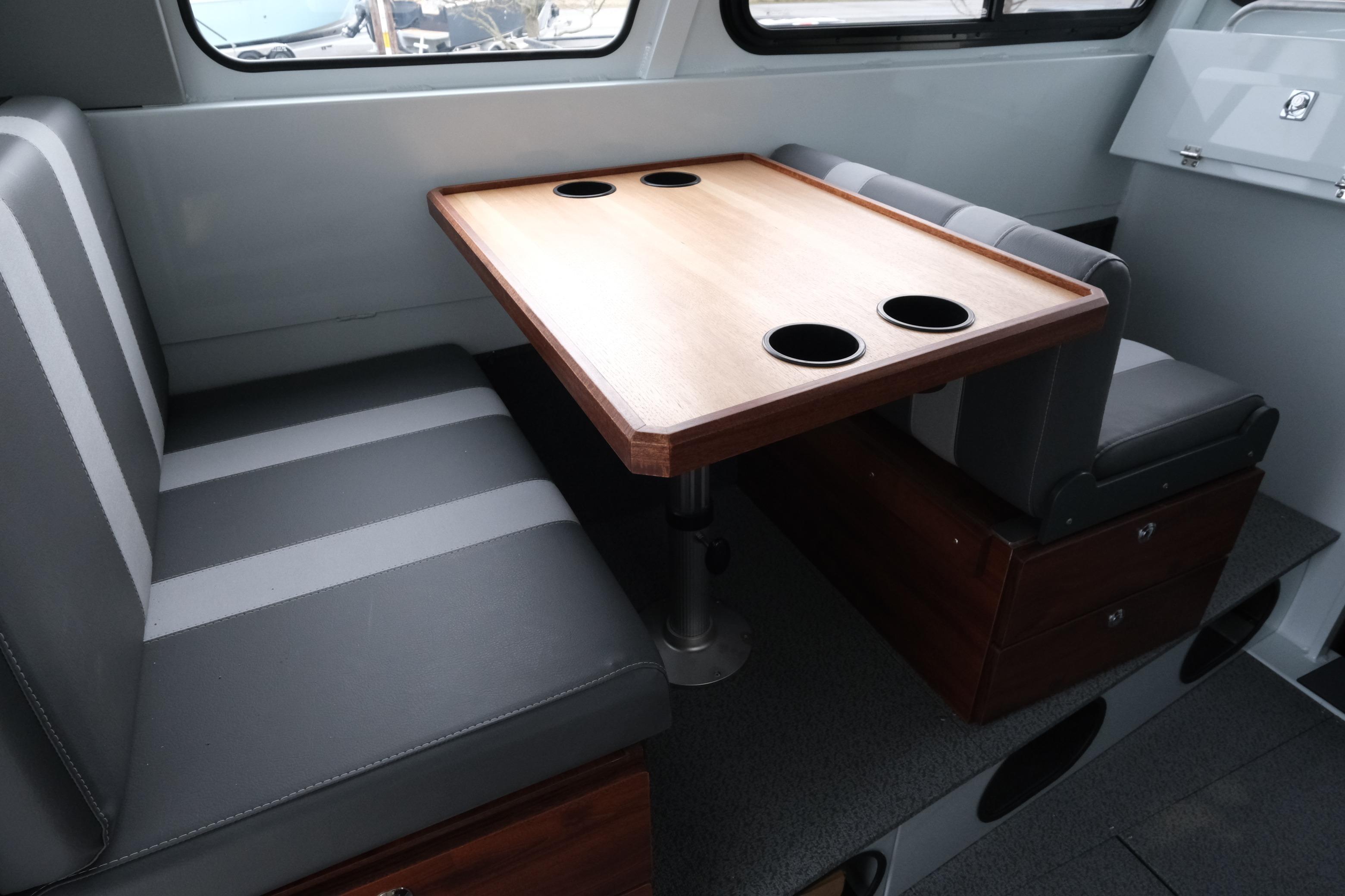 2026 Hewescraft 270 Pacific Explorer interior with dining table and seating.