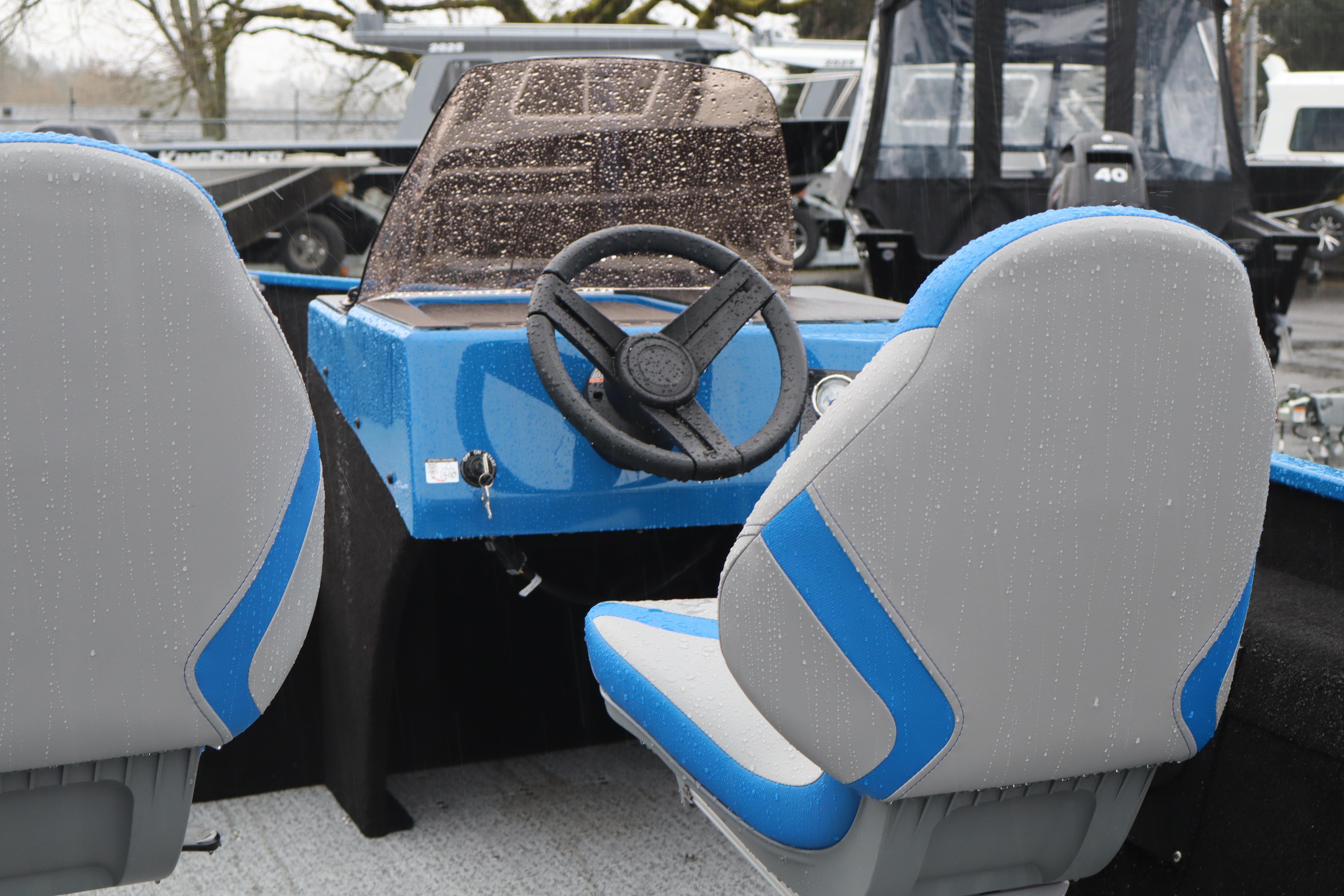 2026 Smoker Craft Lazer 161 boat interior with blue and gray seats, steering wheel, and dashboard.