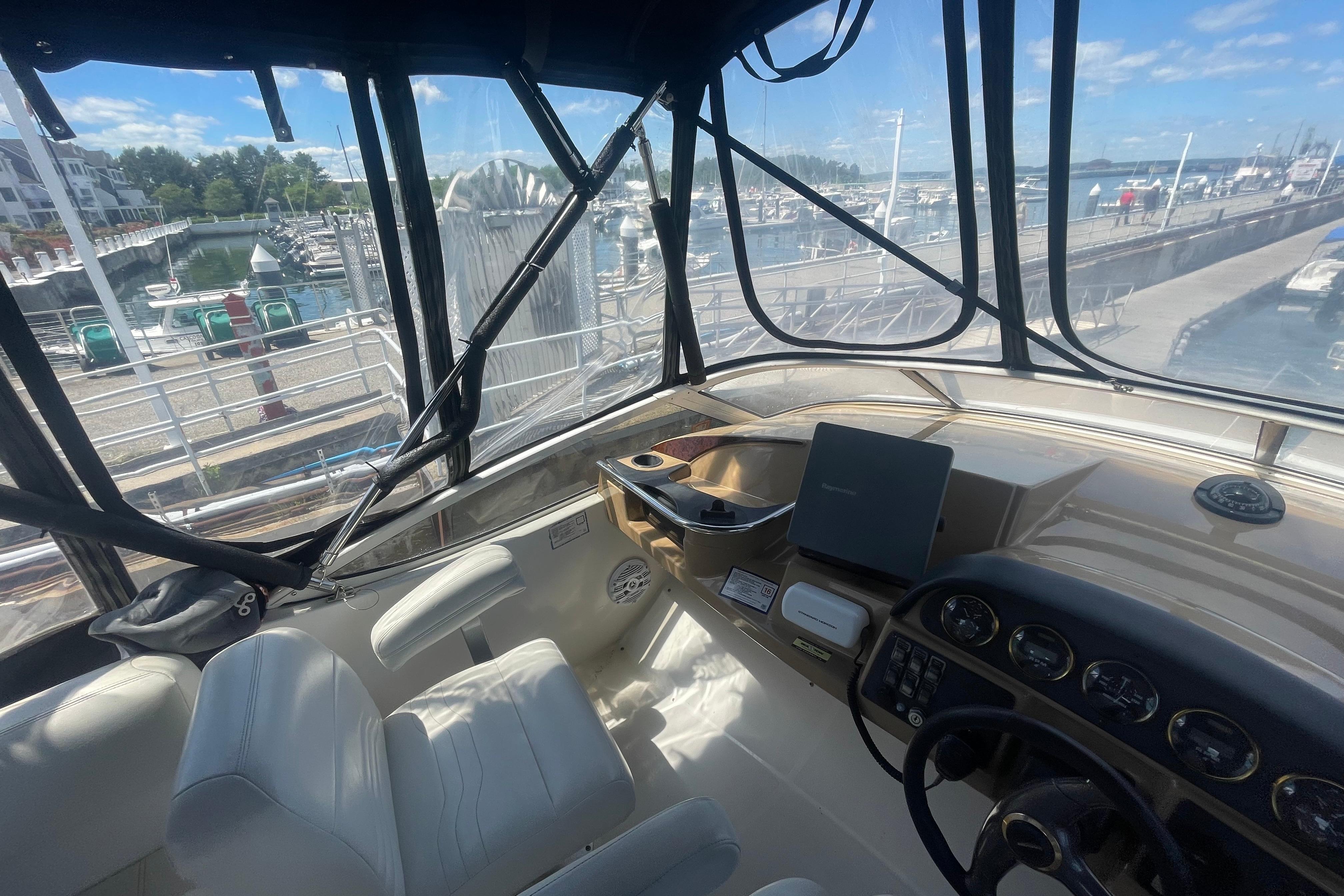 Interior view of 2002 Carver 410 Sport Sedan yacht at marina, featuring helm and seating.