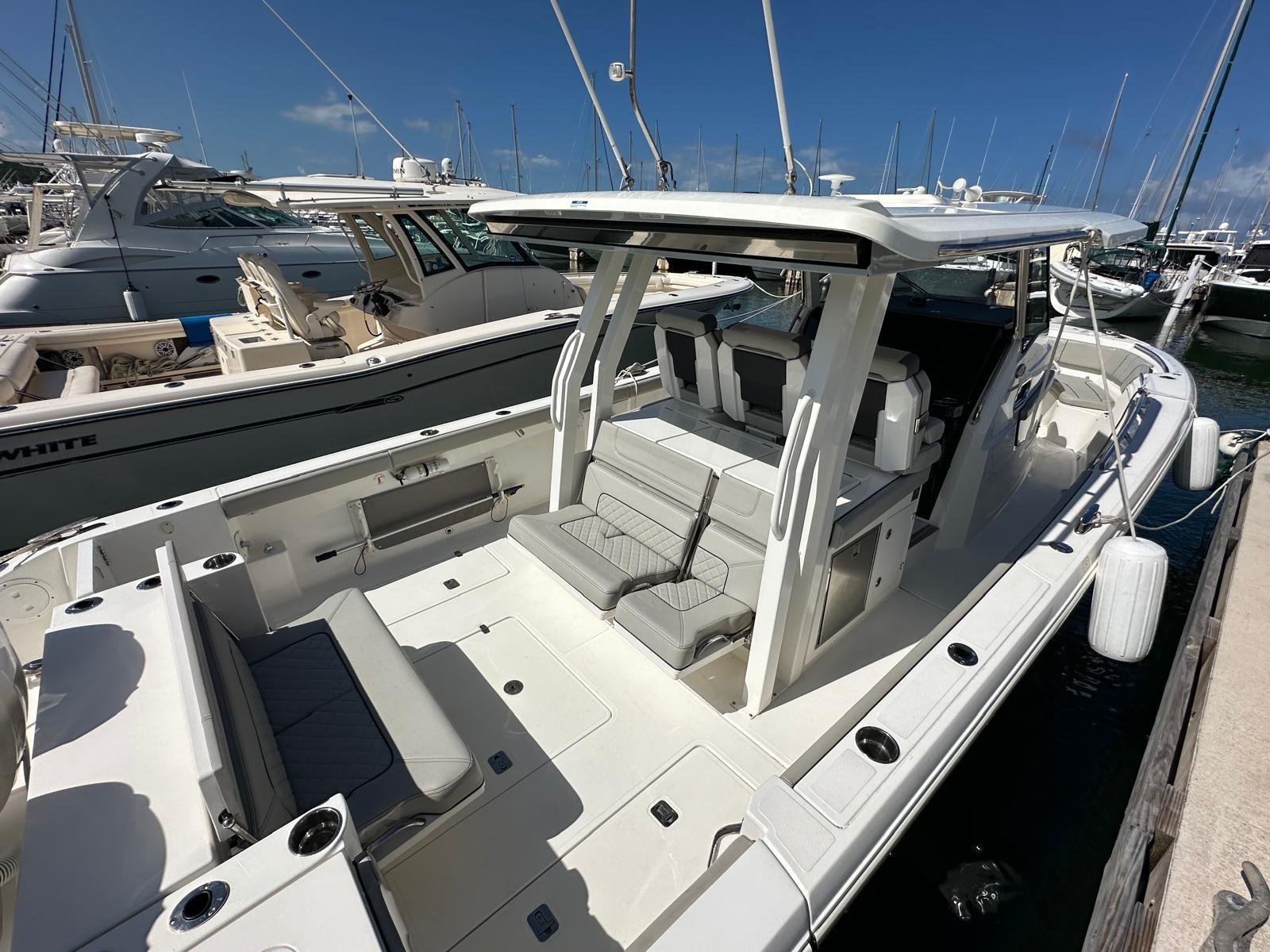 2023 Pursuit S 358 Sport boat docked at marina, featuring spacious seating and sleek design.