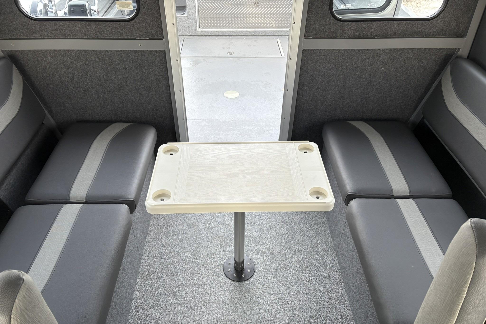 Interior of 2024 Spartan 26 Maximus Pro XL with seating and table setup.