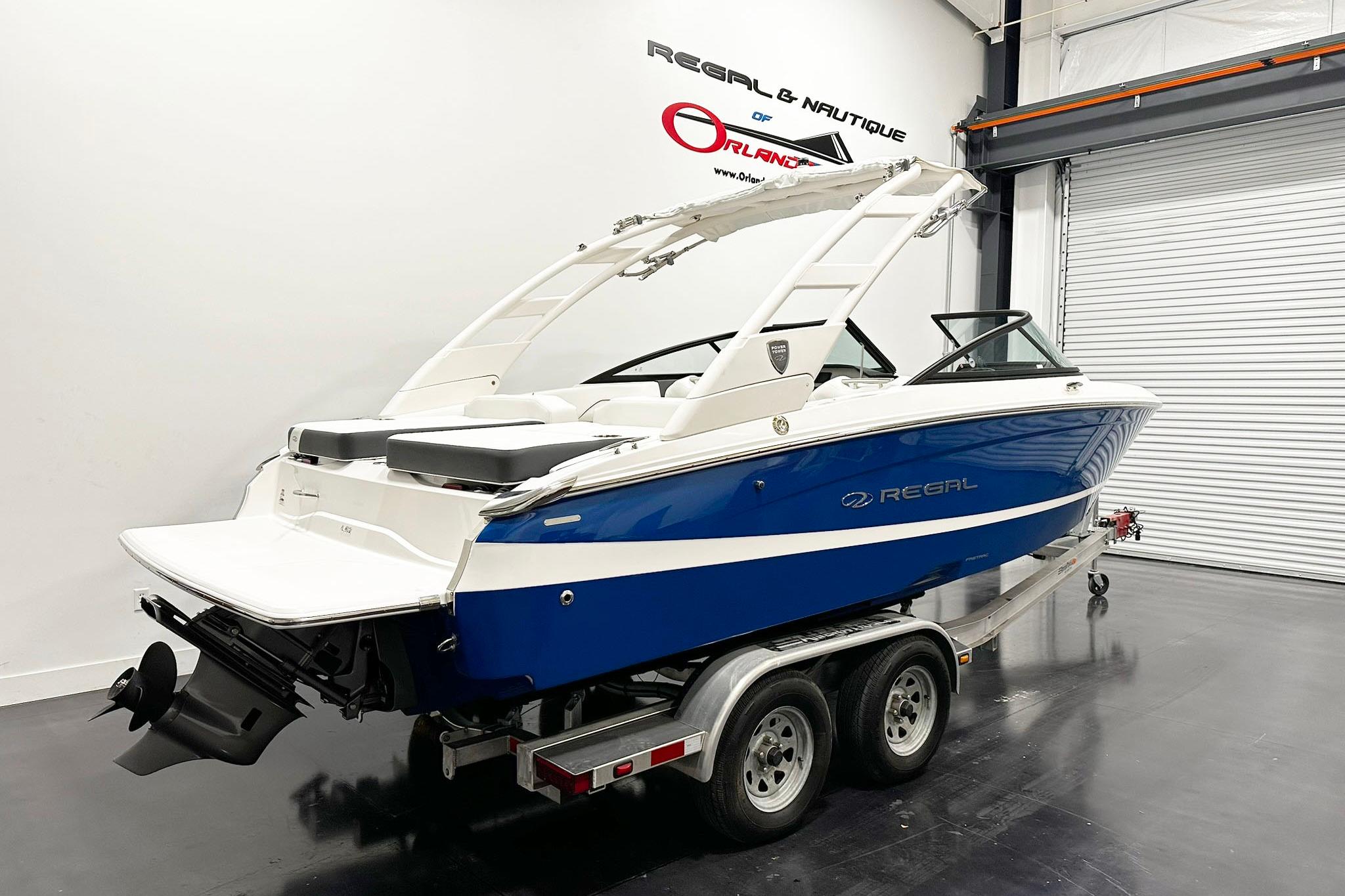 2025 Regal LS2 boat in showroom, blue and white design on trailer.