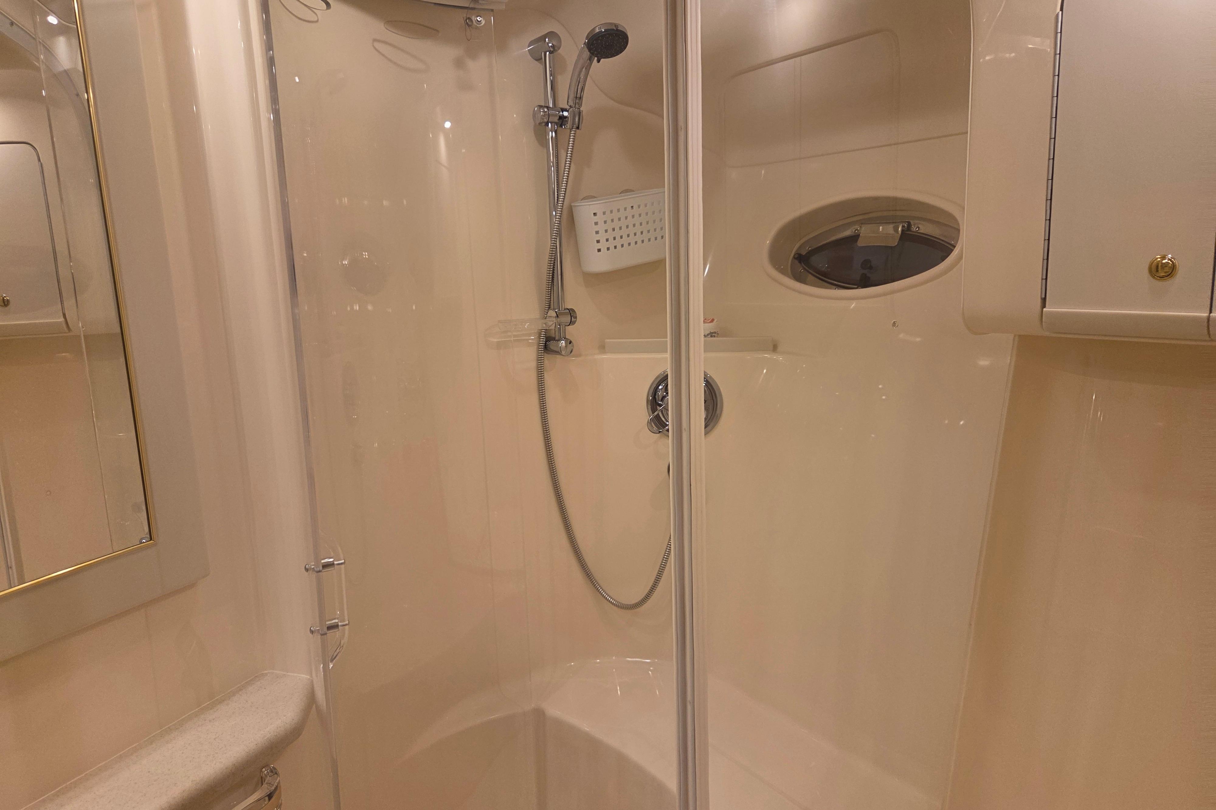 Luxurious bathroom interior of 2000 Sea Ray Sundancer 540 yacht with shower and porthole.