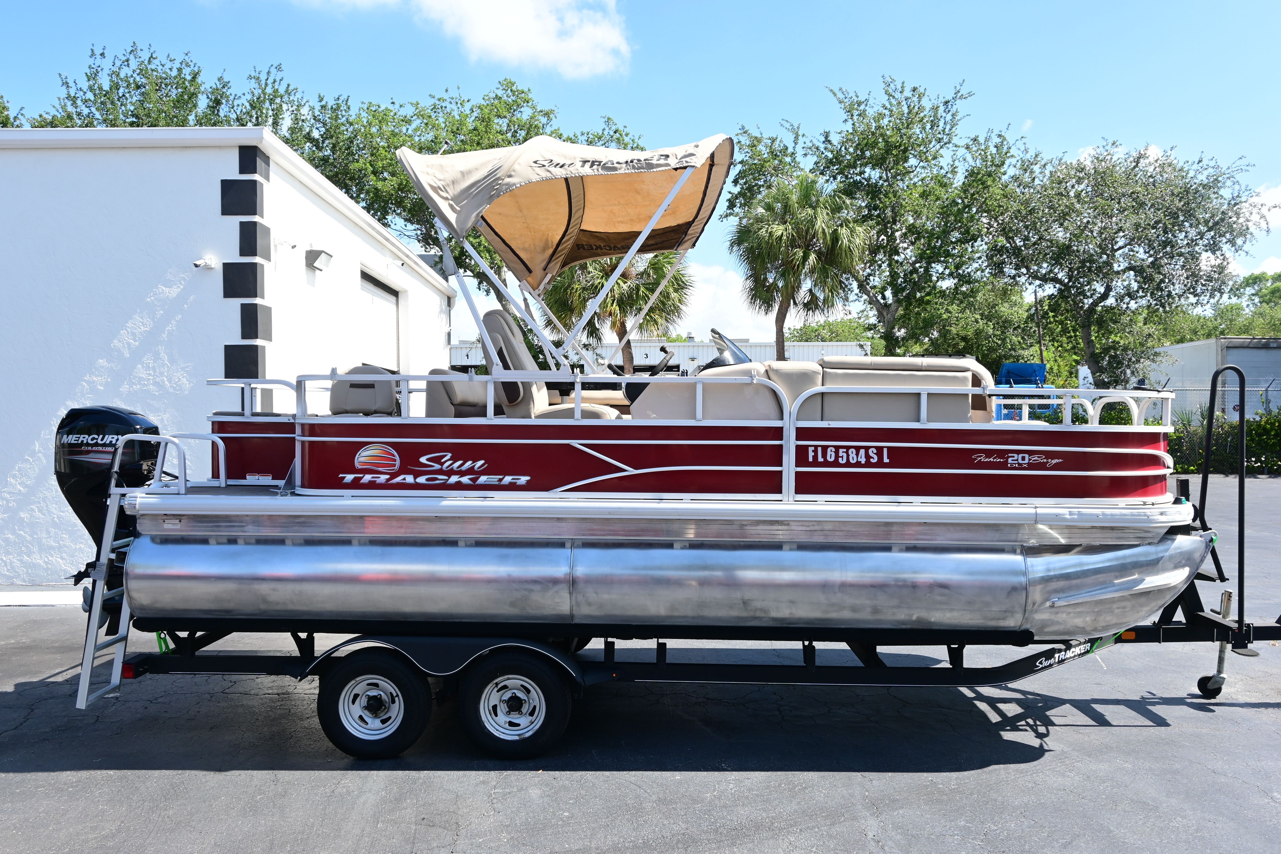 2019 Sun Tracker FISHI pontoon boat with trailer outdoors.