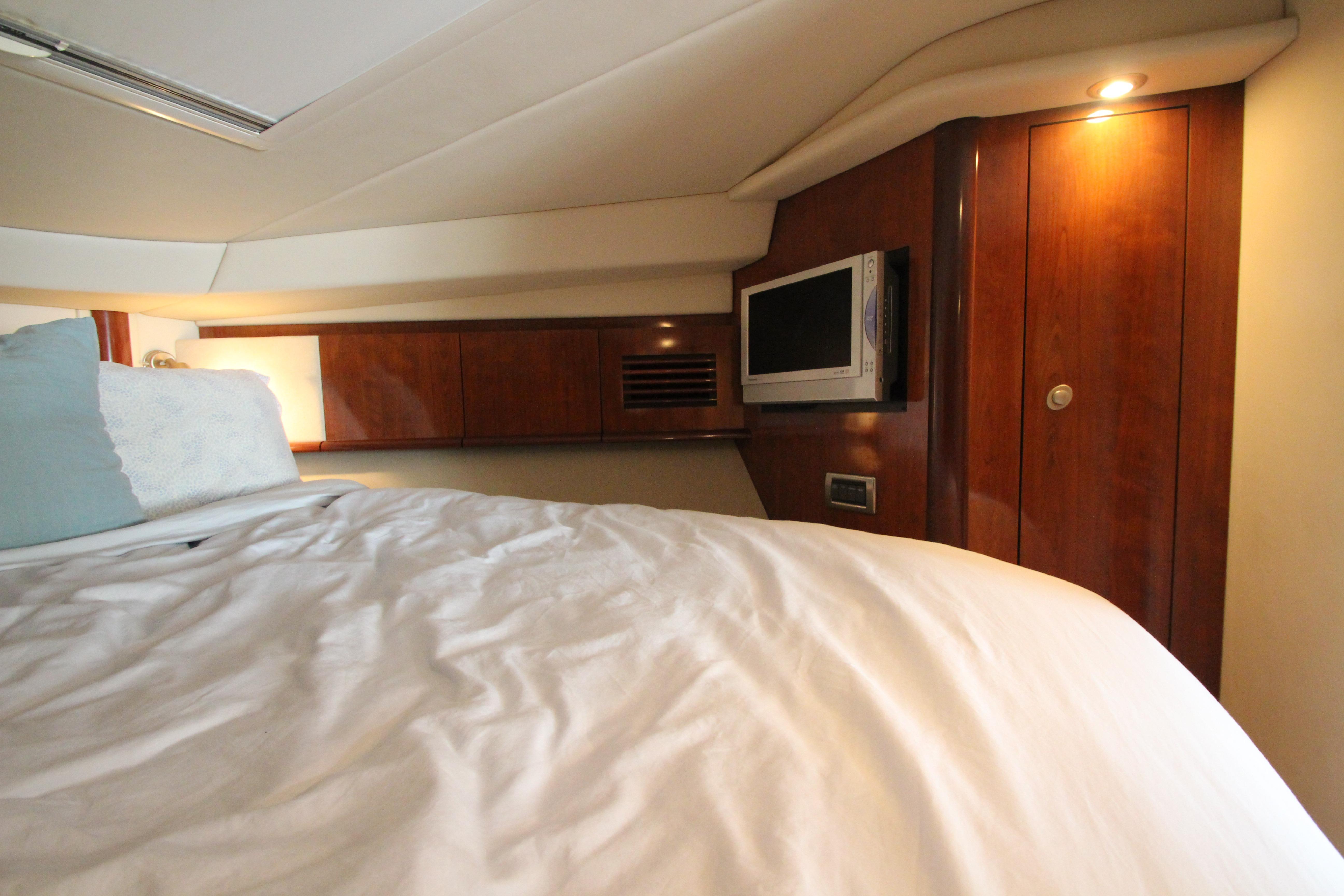 Luxurious cabin interior of 2004 Sea Ray 40 Sundancer yacht with cozy bedding.