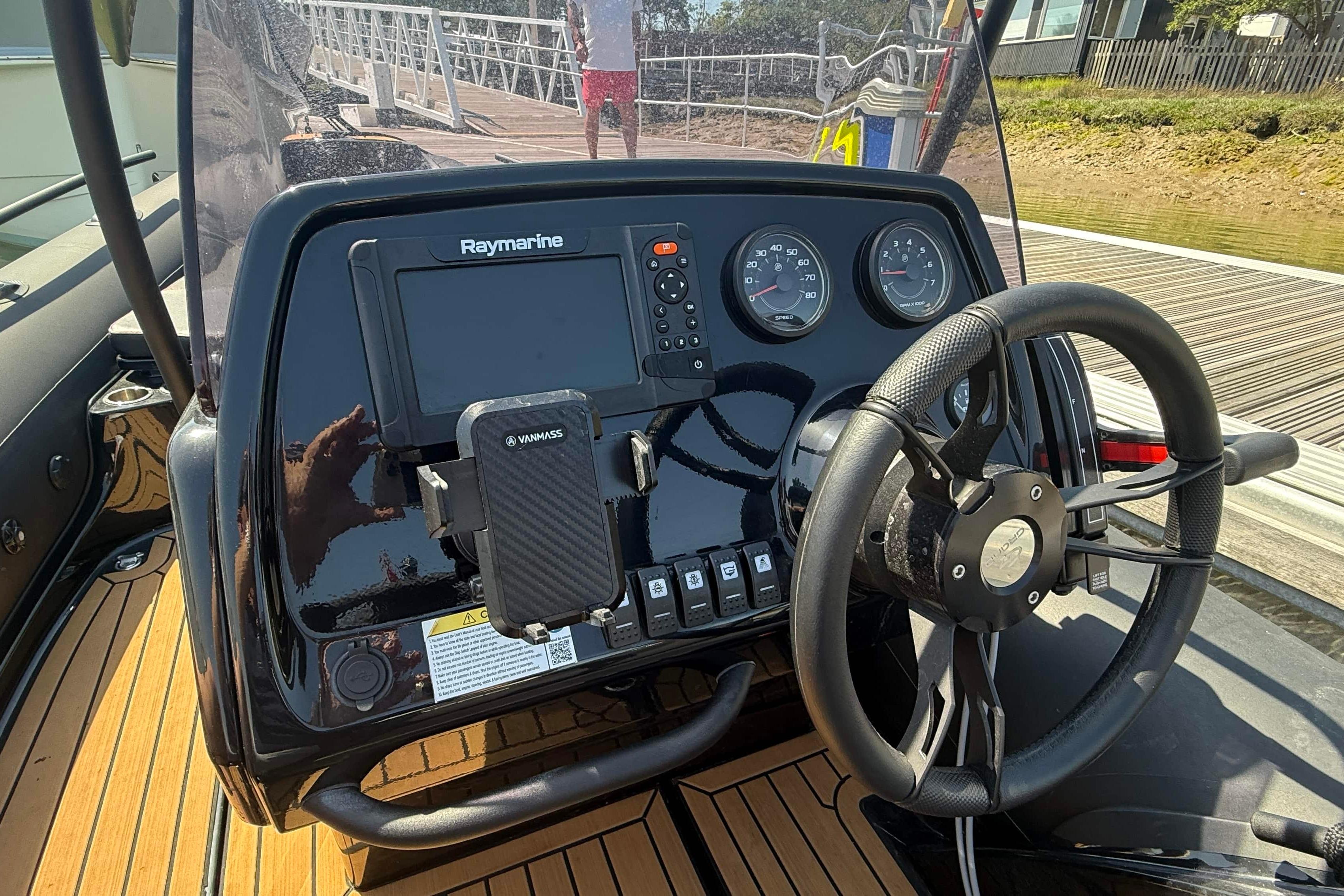 Steering console of 2023 Grand G500 Goldenline boat with Raymarine display and controls.