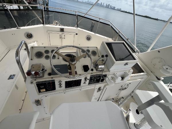 1985 Hatteras 45 Convertible yacht helm with steering wheel and navigation controls.