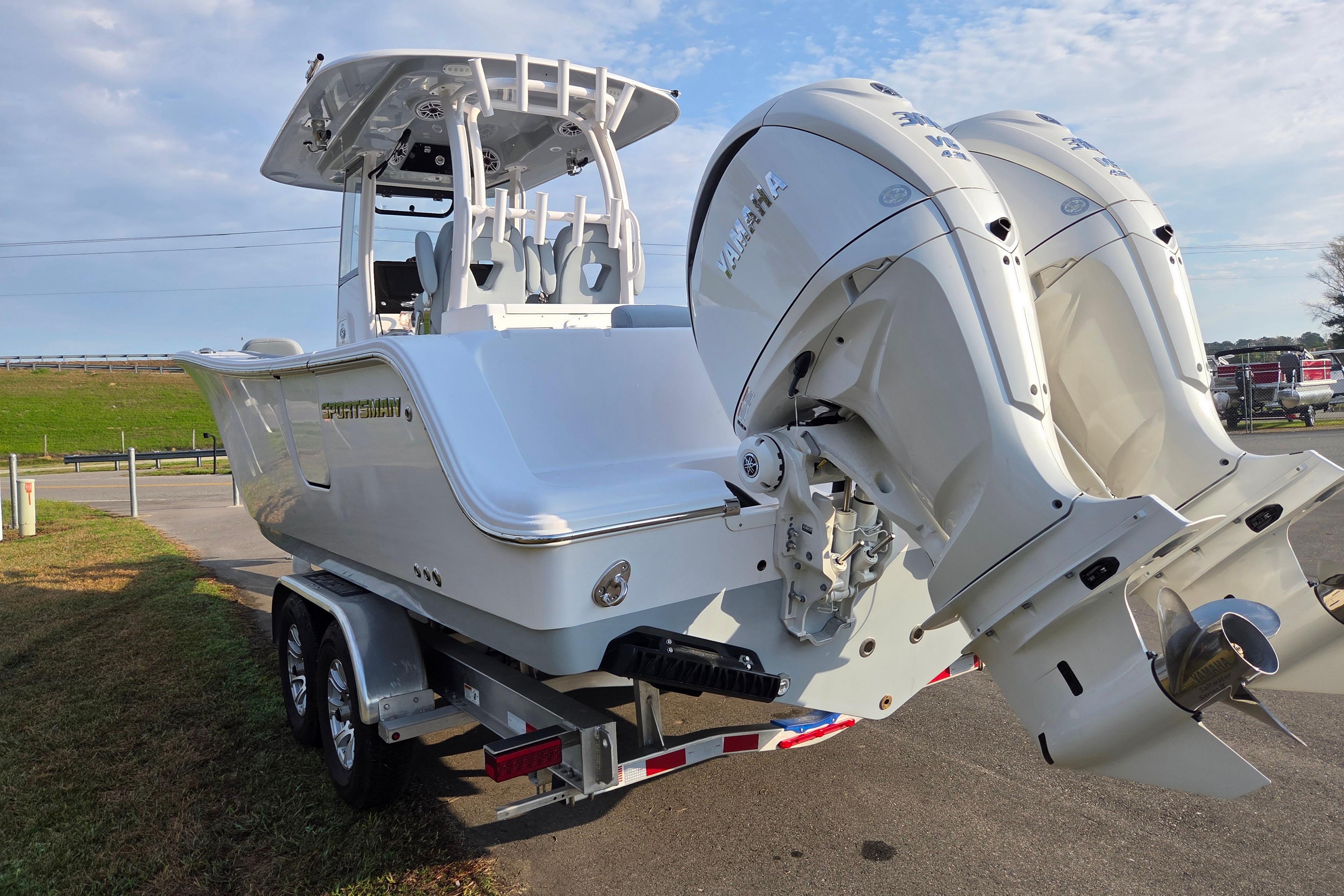 2026 Sportsman Open 282 Center Console boat on trailer with dual outboard engines.