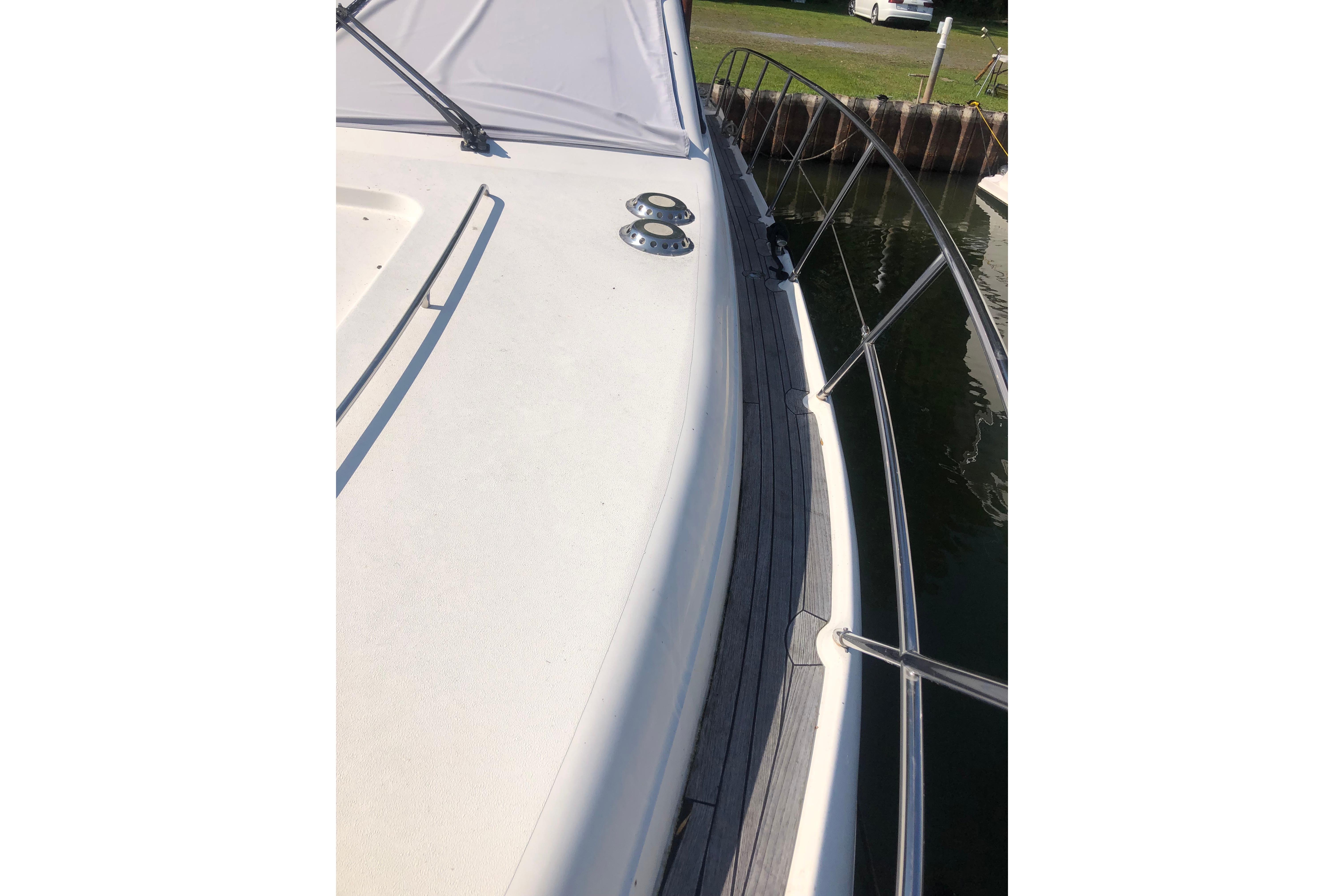 2002 Birchwood Challenger 460 Flybridge yacht deck with railing, docked by water.