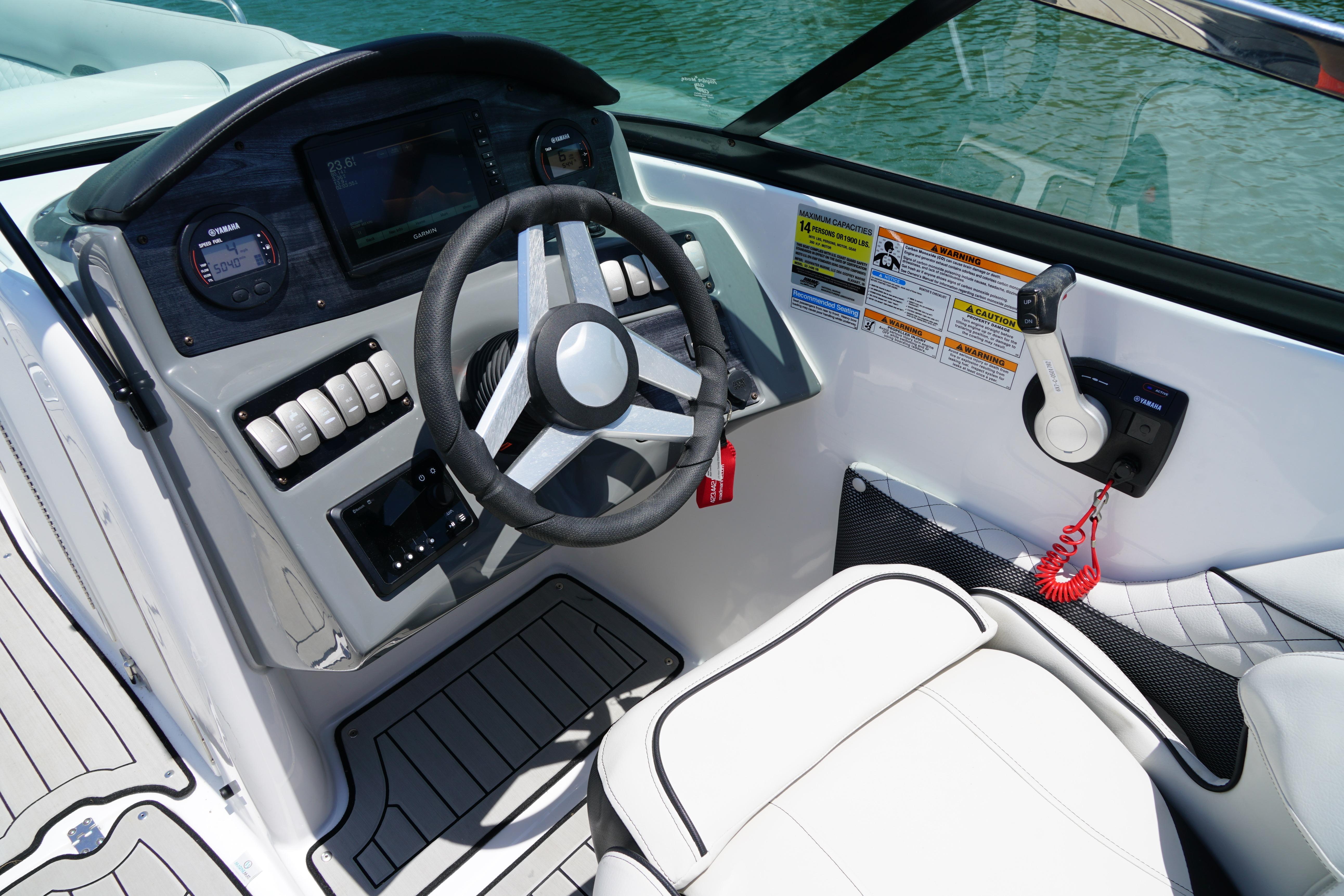2020 Hurricane SunDeck 2486 OB boat cockpit with steering wheel and control panel.