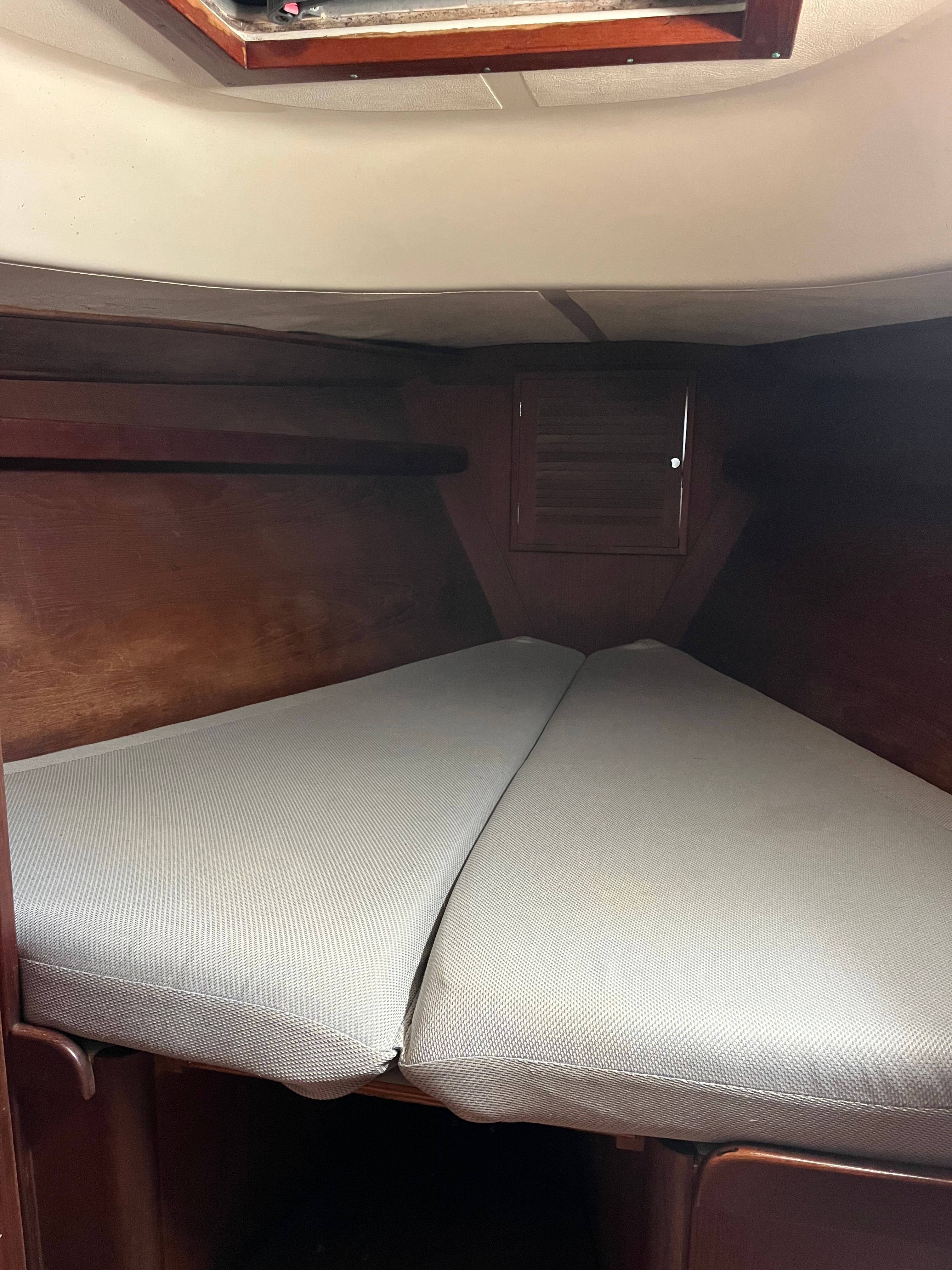 Interior of a 1981 Tartan Sloop with a V-shaped berth and wooden paneling.
