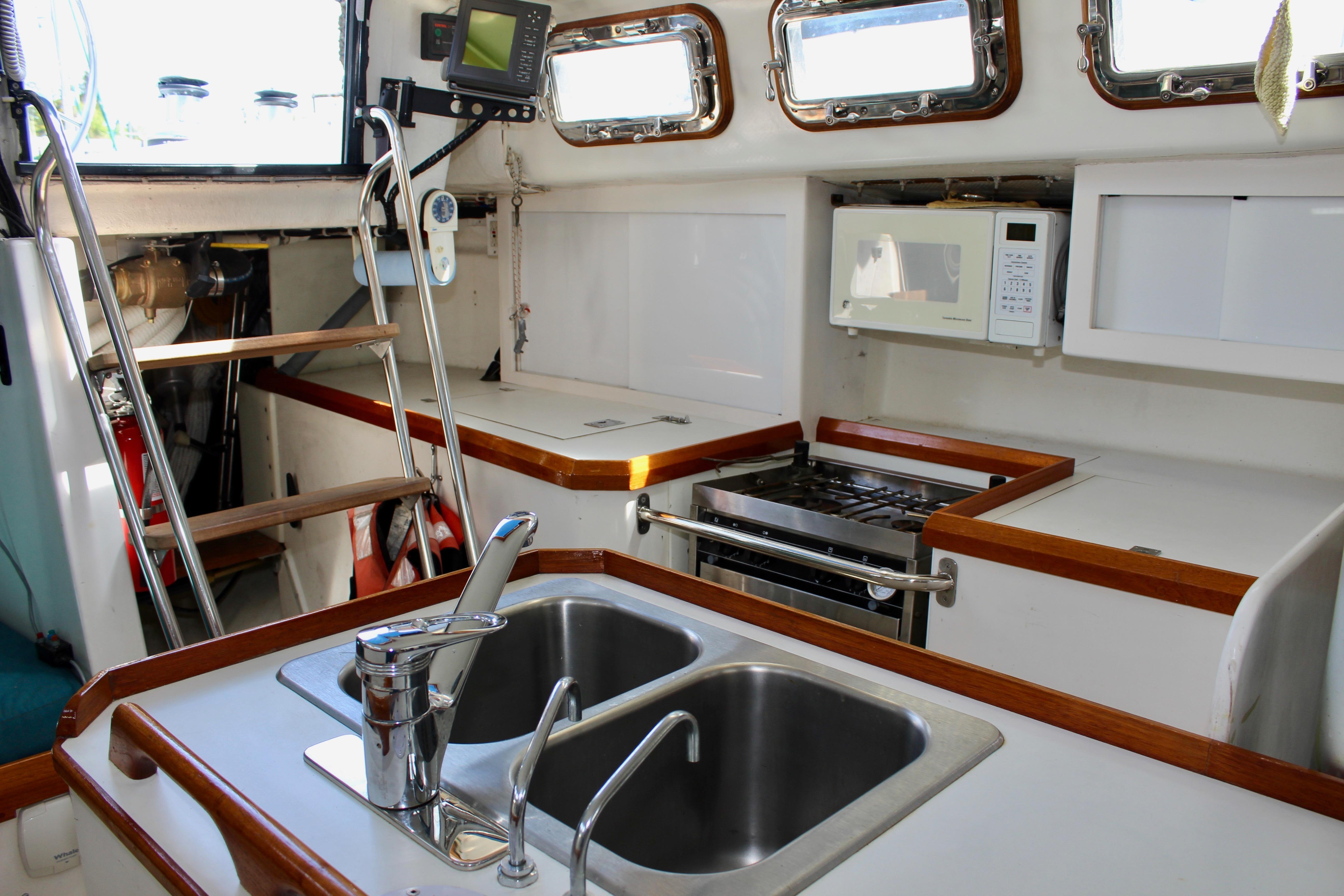 Interior of 1993 Freya 39 yacht kitchen with sink, stove, and microwave.