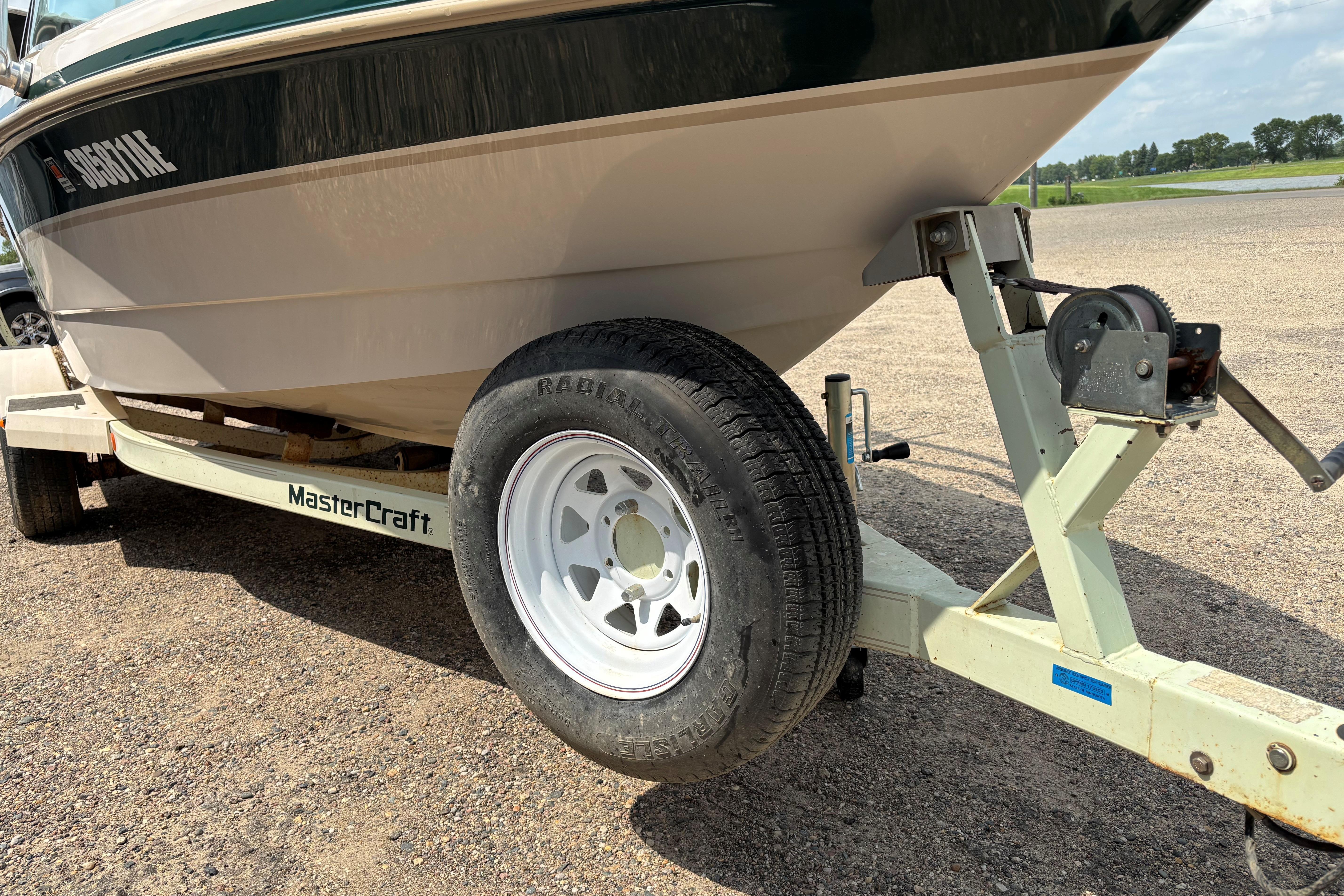 1999 MasterCraft 205 PRO STAR boat on trailer, close-up of wheel and hull.