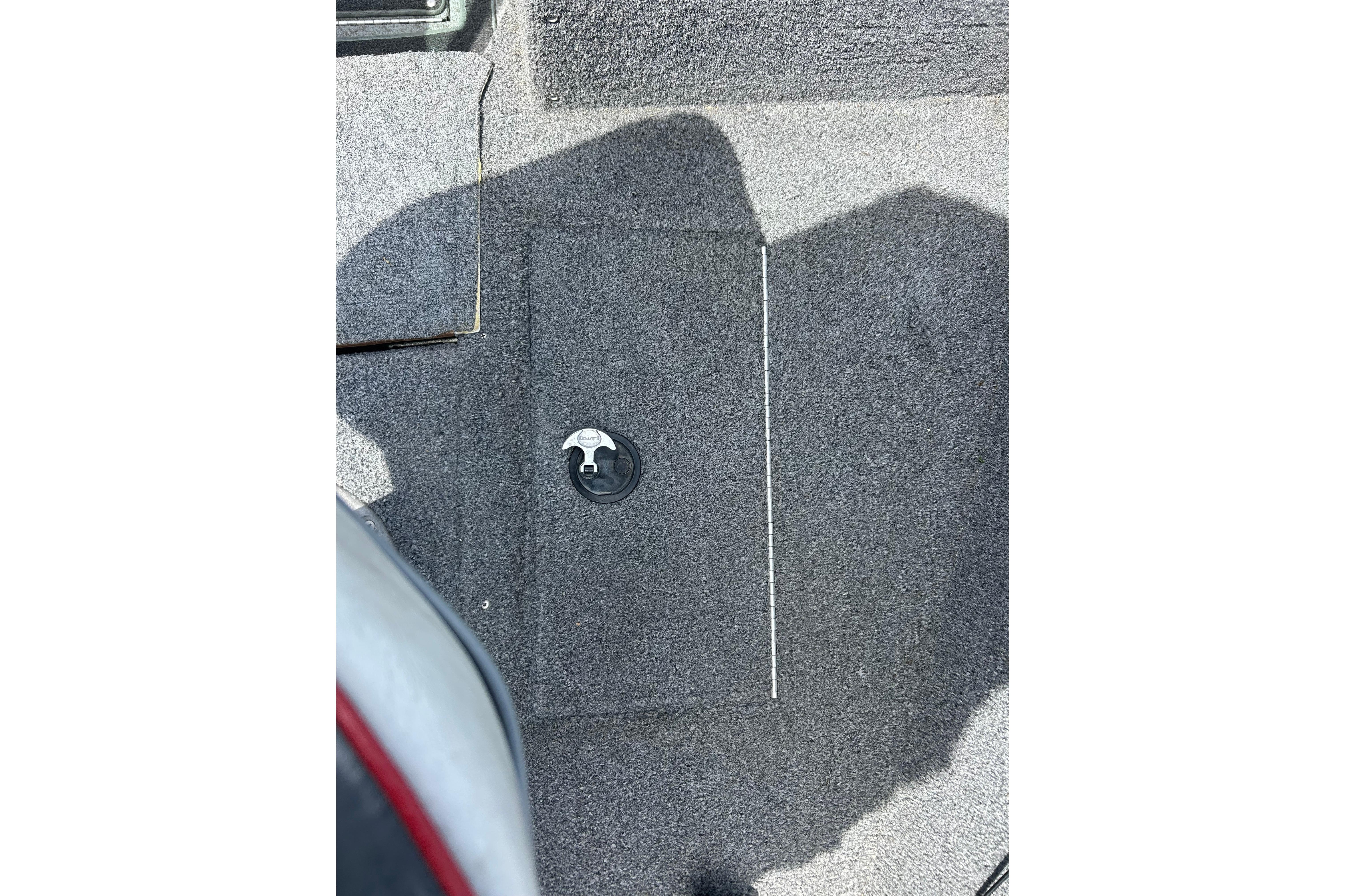 Carpeted deck of a 2008 Lund 1850 Fisherman boat with a hatch handle.