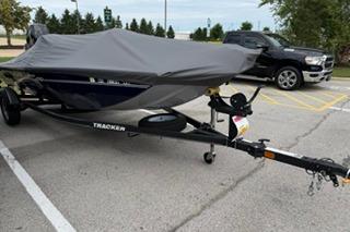 2020 Tracker Pro 170 boat covered on trailer in parking lot.