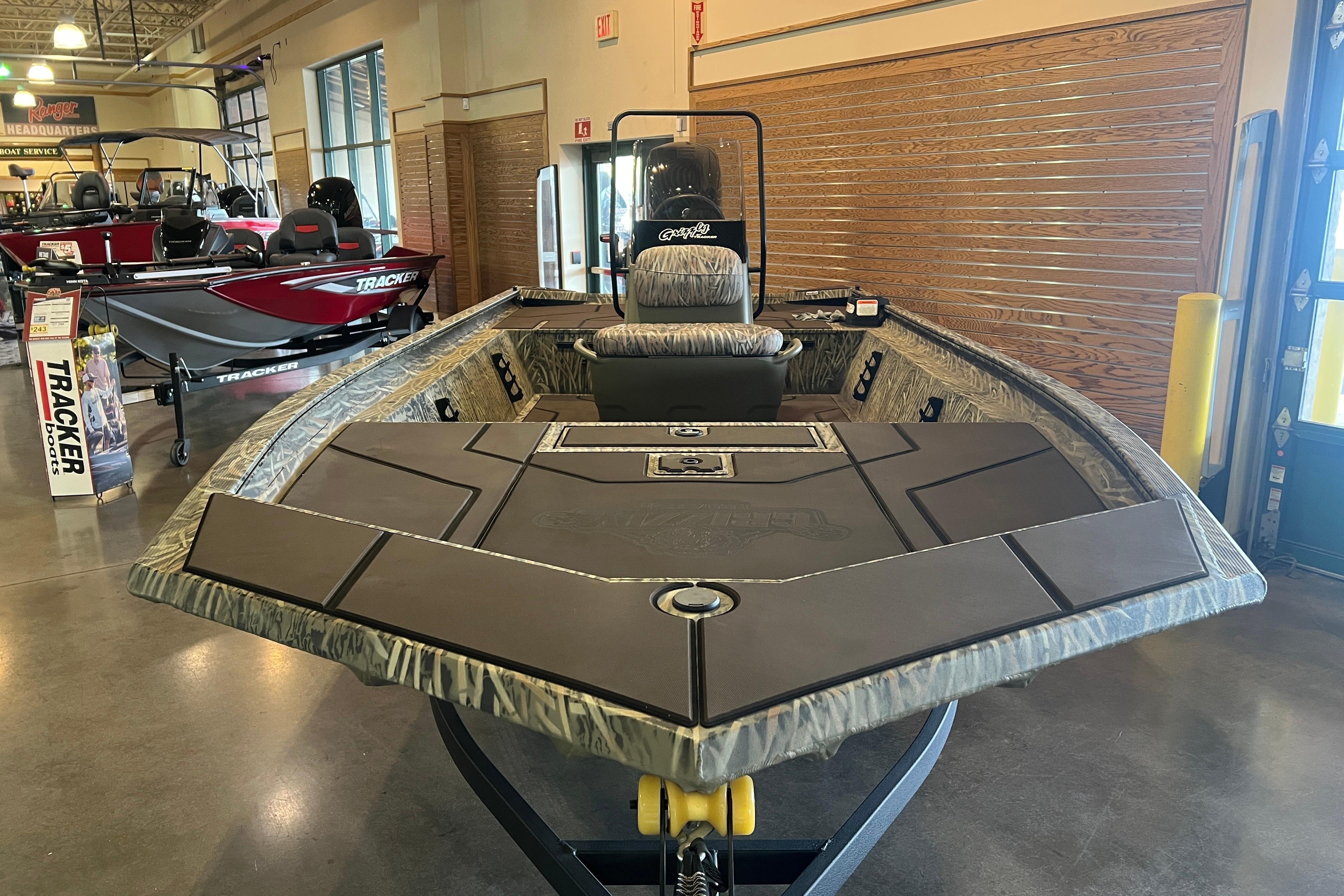 2026 Tracker Grizzly 1860 CC boat displayed in showroom with camo design.