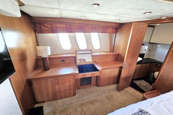 Luxurious interior of 2005 Sunseeker Manhattan 66 yacht with wooden cabinetry and natural light.