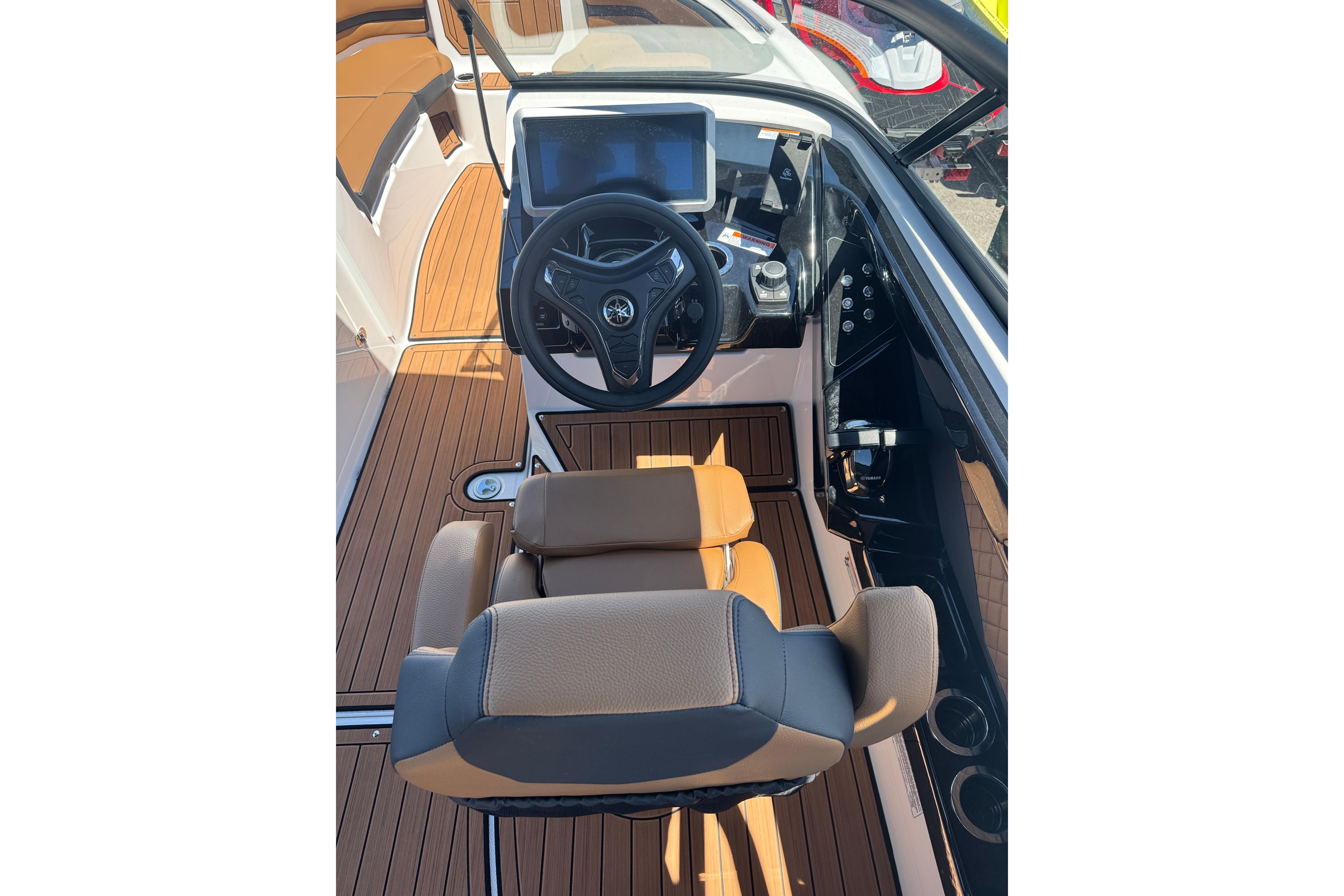 2026 Yamaha Boats 252SD cockpit with modern steering and controls, featuring sleek design and wood accents.