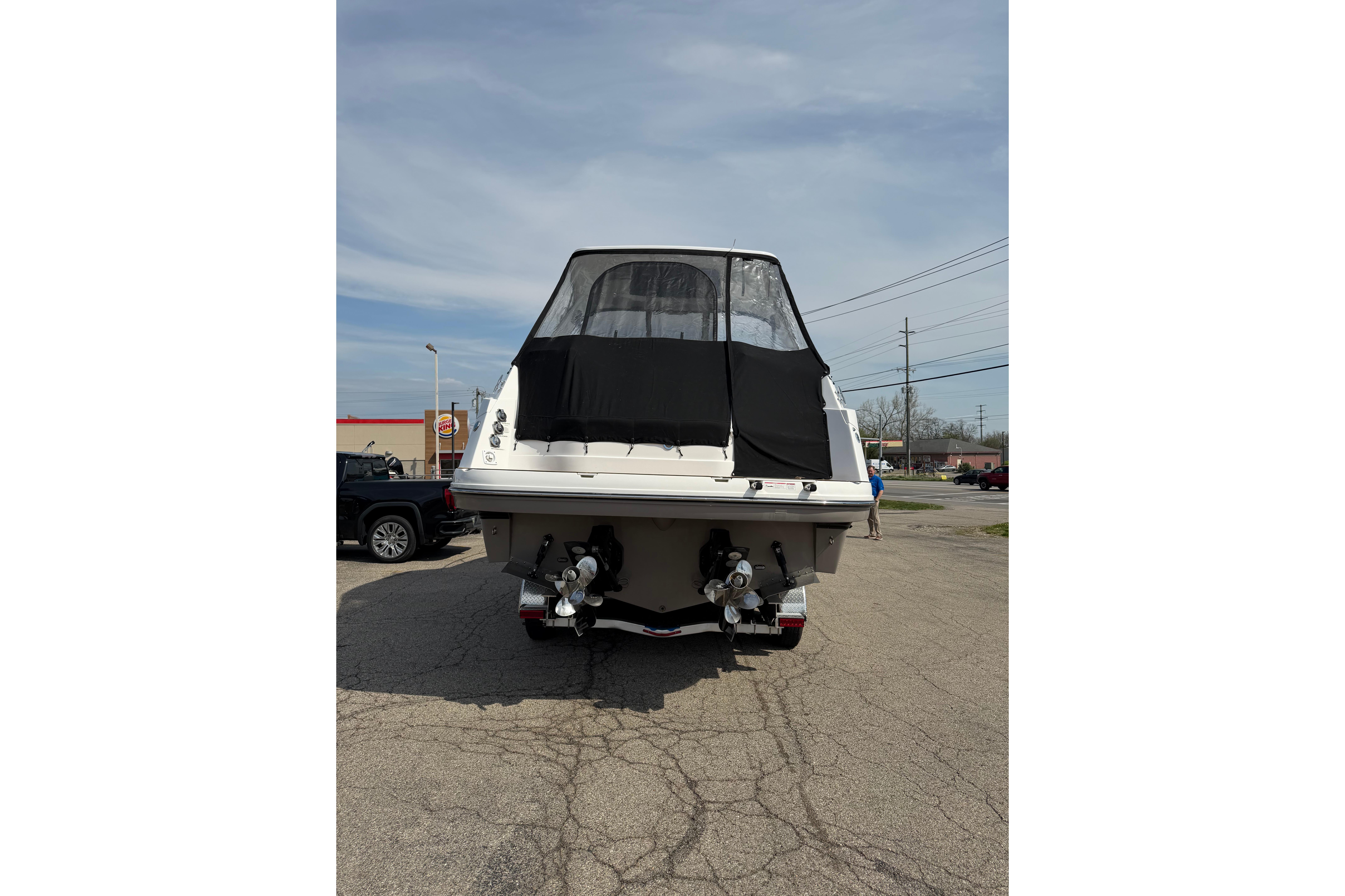2019 Rinker EX 320 boat rear view with covered cockpit and dual propellers.