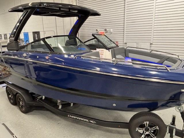 2026 Chaparral SSX 6 boat in showroom, sleek blue design on trailer.