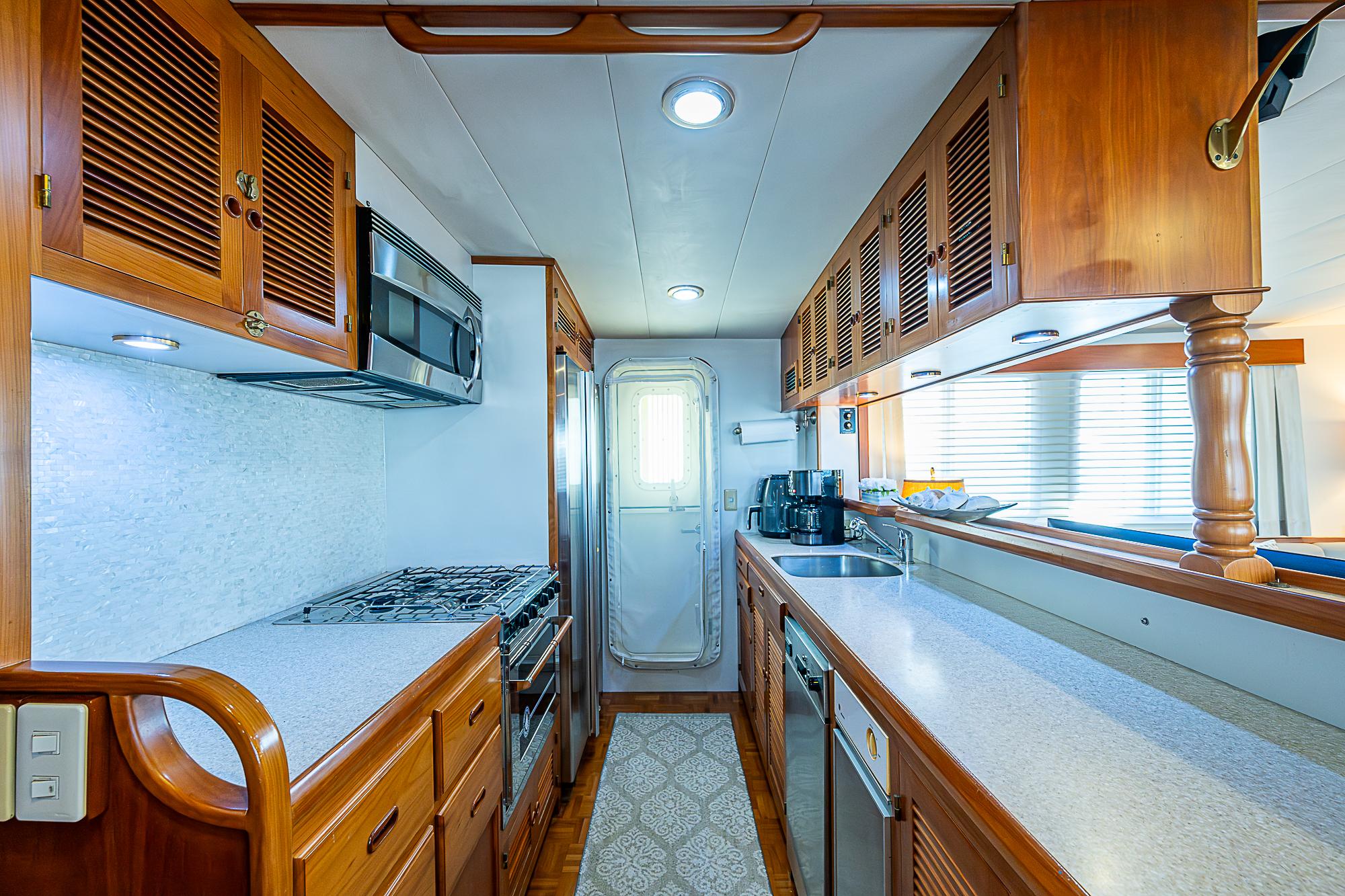 Luxurious 2001 Kadey-Krogen 58 yacht kitchen with wooden cabinetry and modern appliances.