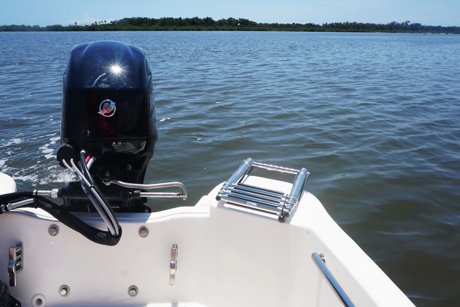A 2026 Boston Whaler 130 Super Sport on calm water with an outboard motor.