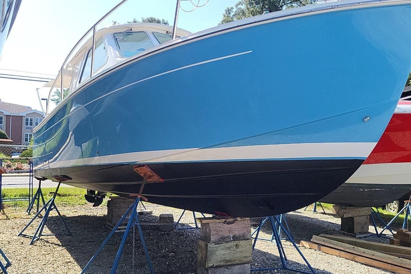2006 Back Cove 29 boat with blue hull on stands, displayed outdoors.