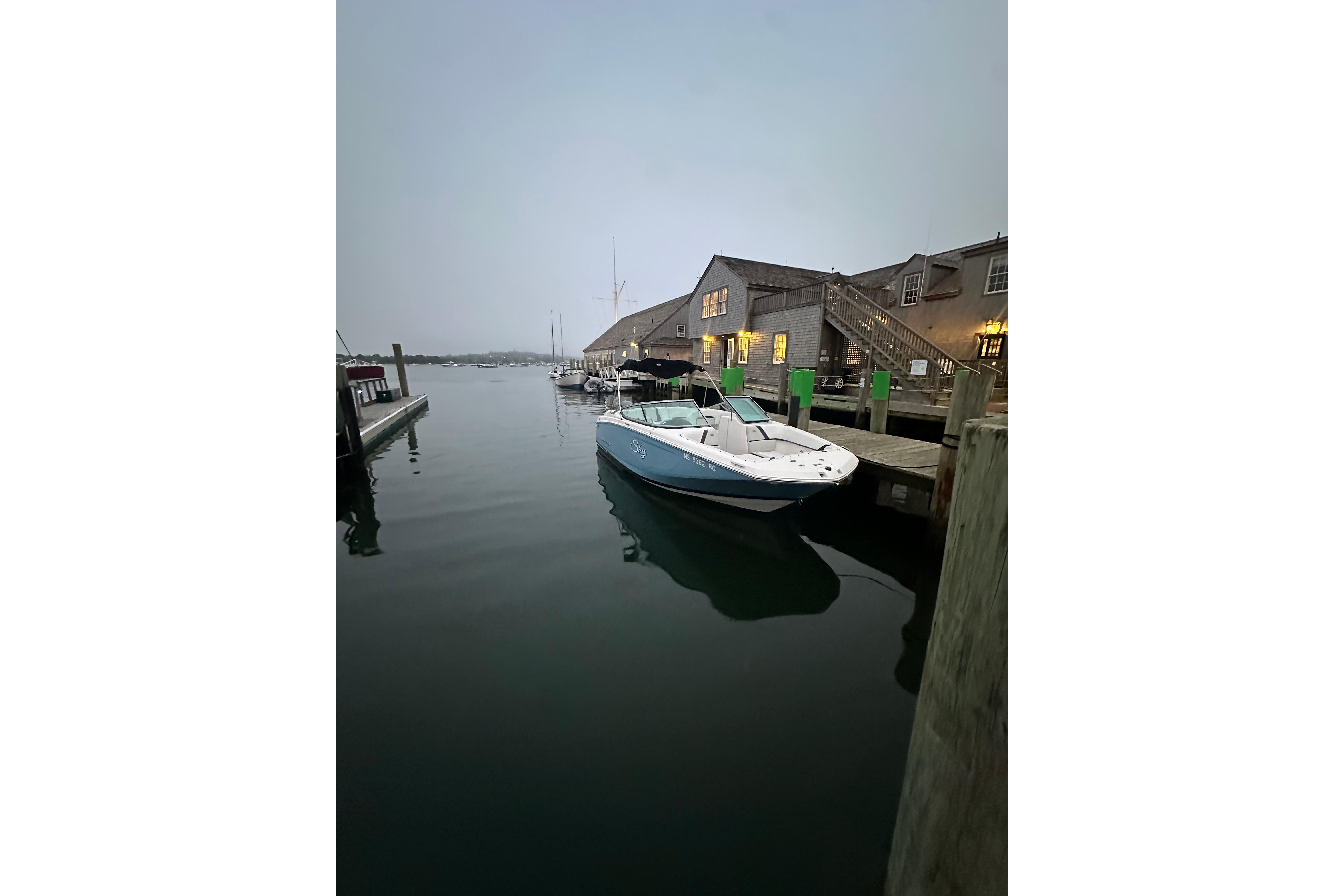2017 Regal 23 OBX boat docked at a marina during twilight.