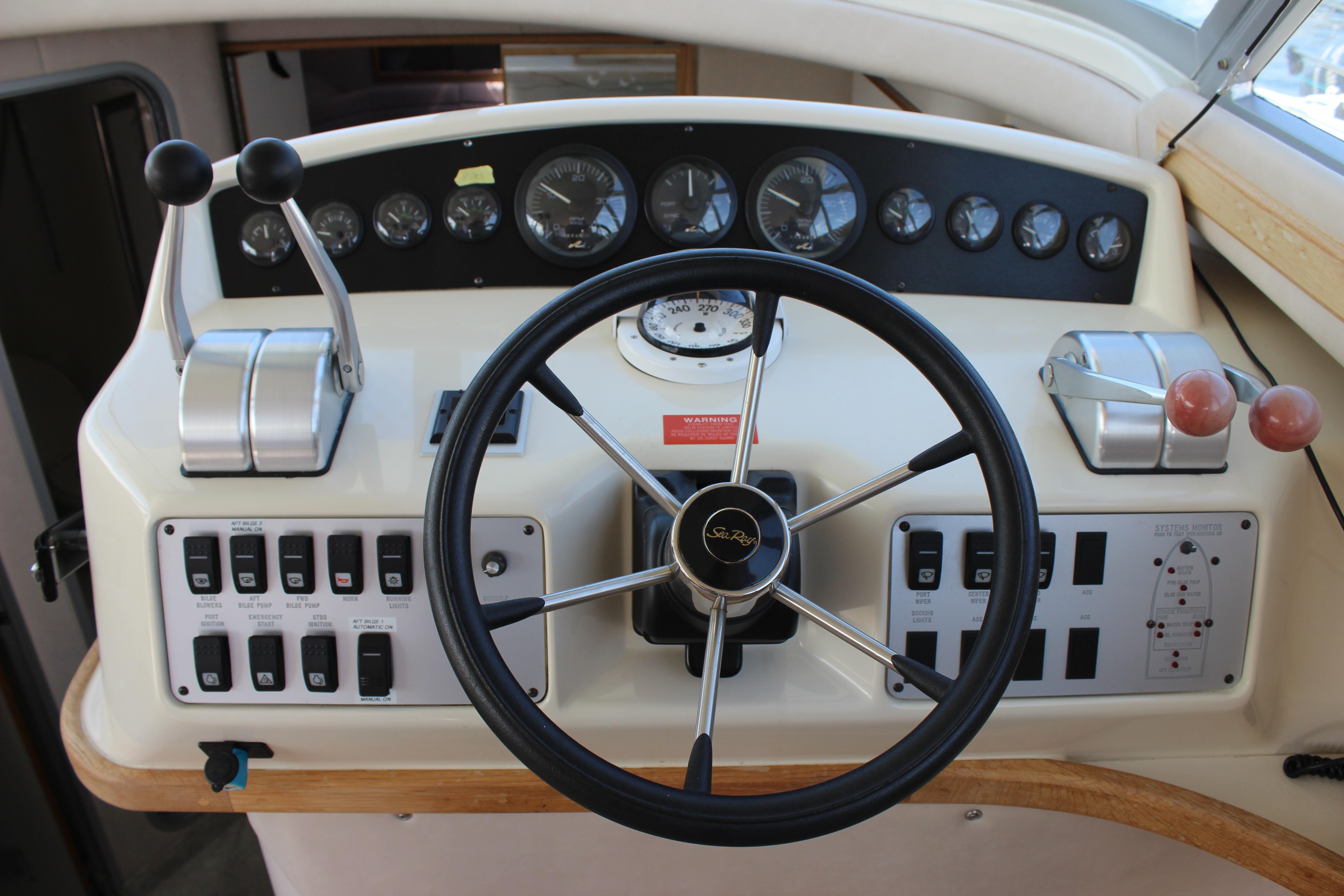 Control panel of a 1995 Searay 370 S boat with steering wheel and gauges.