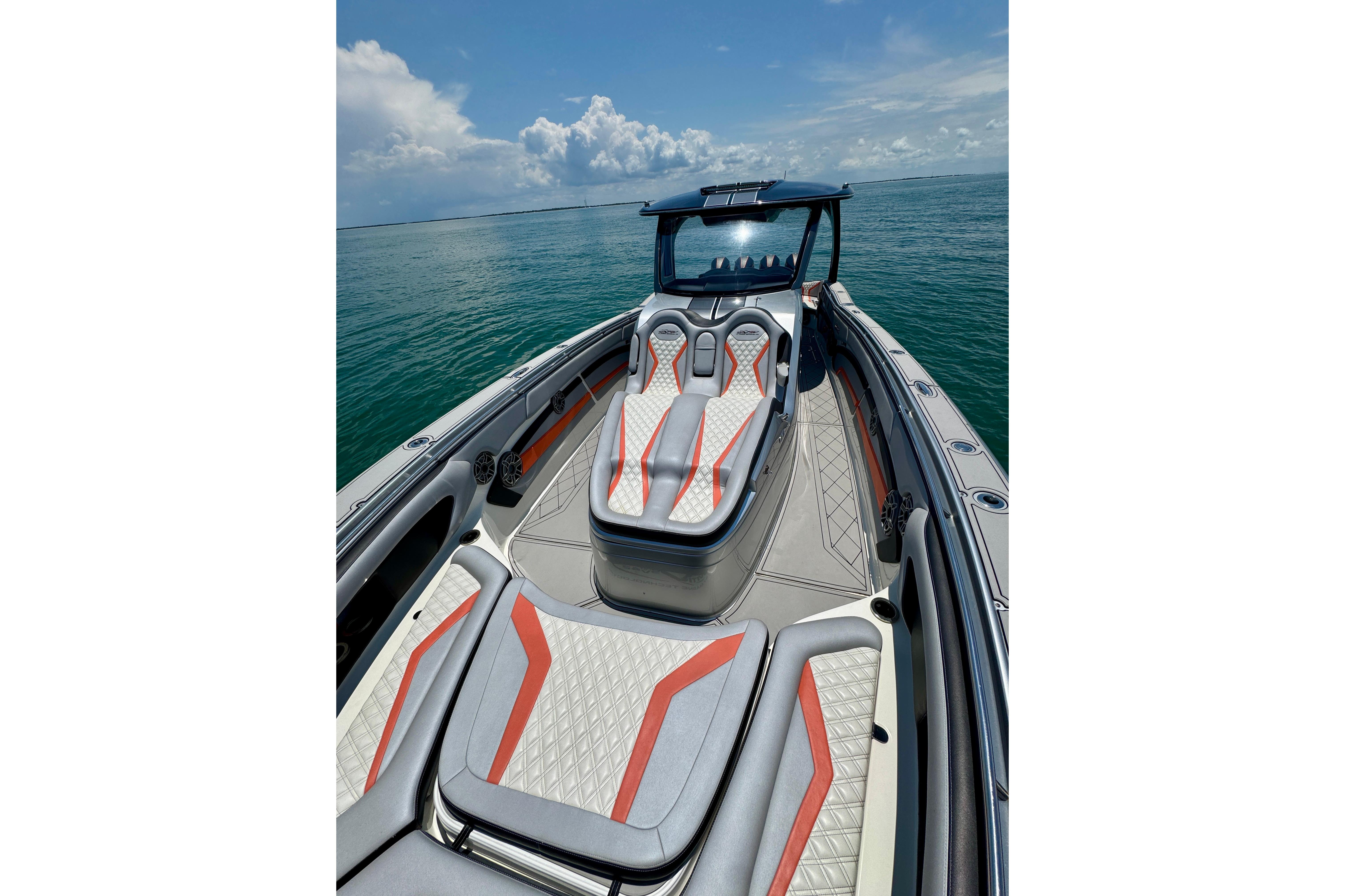 2017 MTI V42 boat with sleek seating on open water under a blue sky.