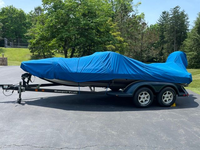 A 2004 Ranger 190 Reata boat covered on a trailer, parked on a paved area.