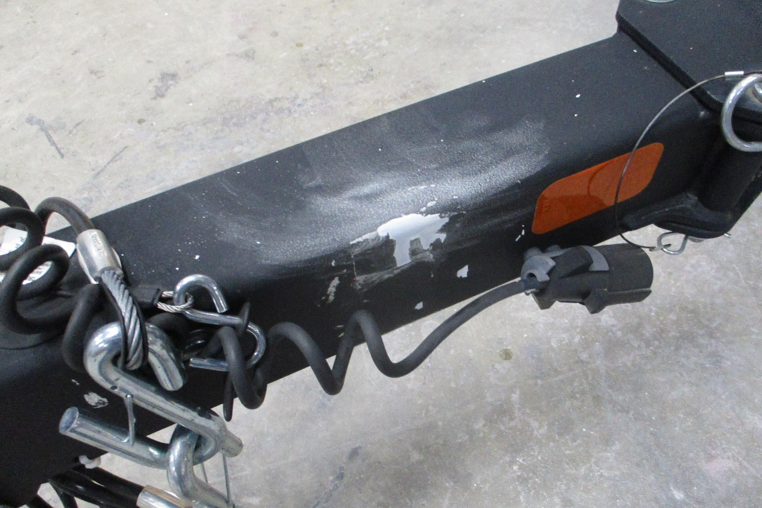 Trailer hitch of a 2024 Tahoe 1950 with safety chains and electrical connector.