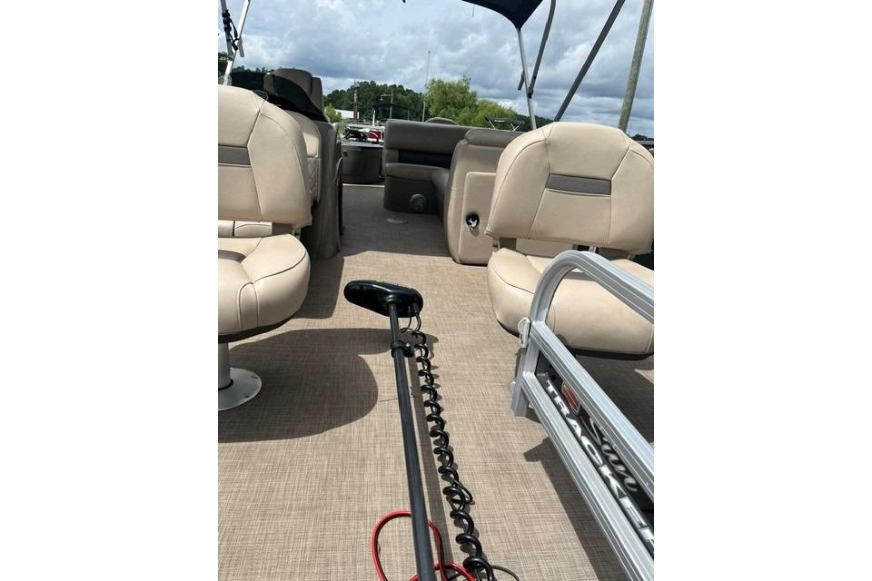 2023 SUNTRACKER Fishing Barge 20 interior with beige seating and fishing equipment.