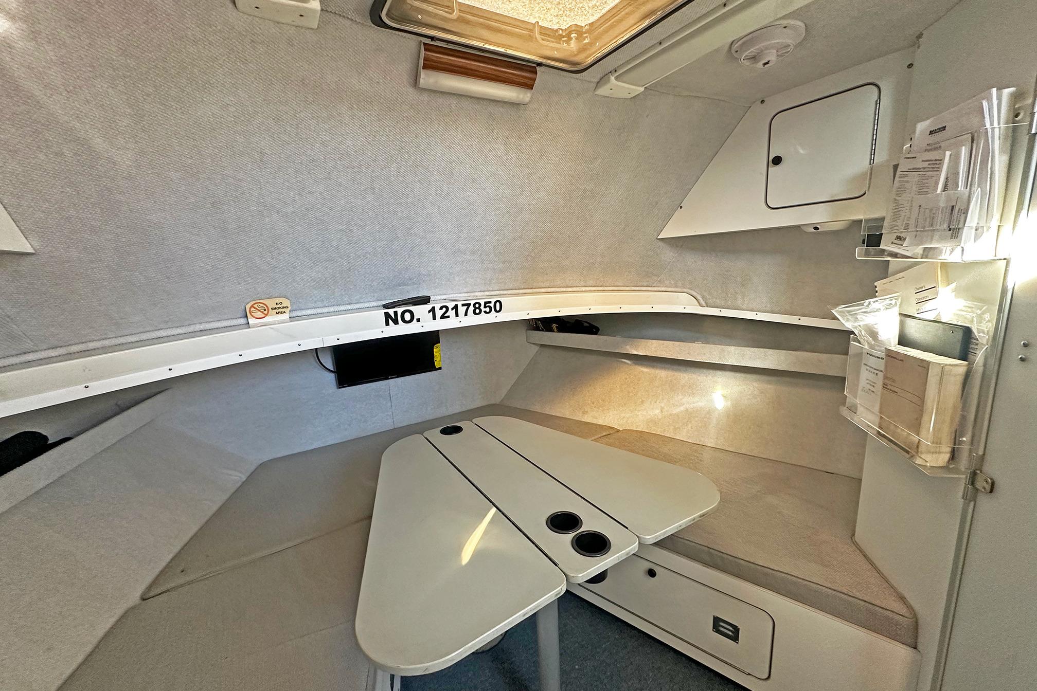 Interior cabin of a 1990 Boston Whaler 36 Defiance boat, featuring seating and storage.