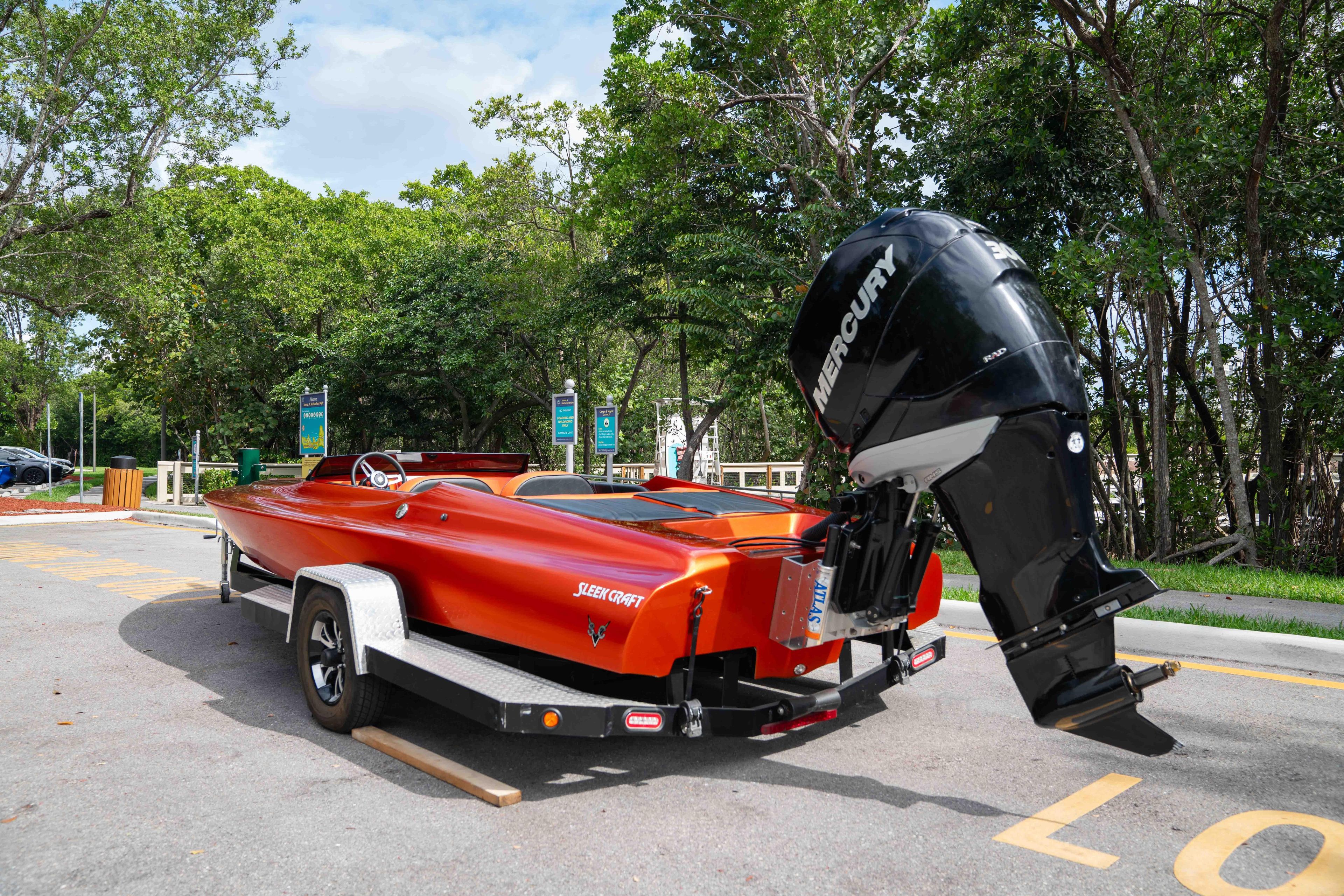 1984 Sleekcraft Aristocrat 20 boat with Mercury engine on trailer, parked outdoors.
