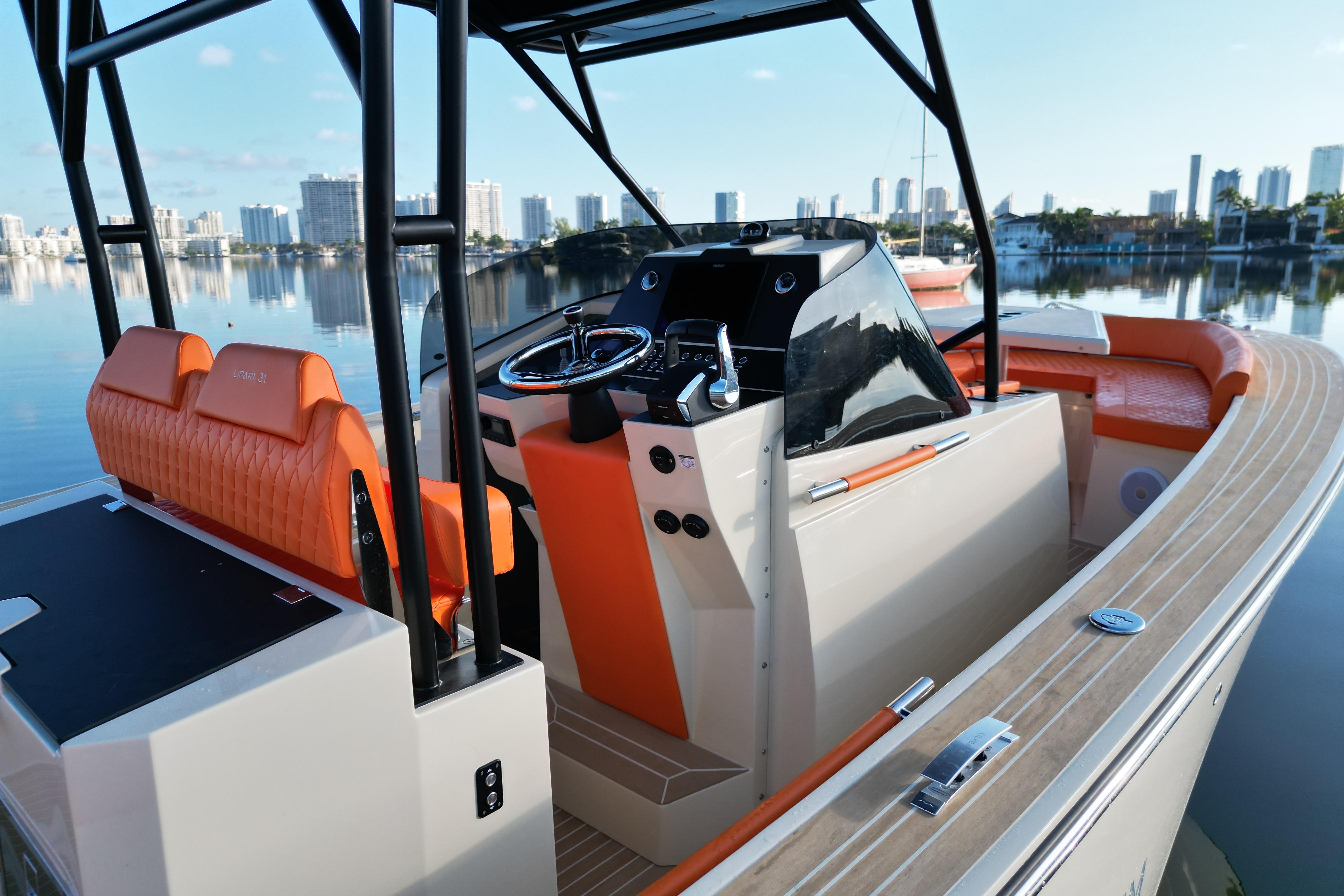 2026 Lilybaeum Lipari 31 boat with orange seating, sleek design, and city skyline backdrop.