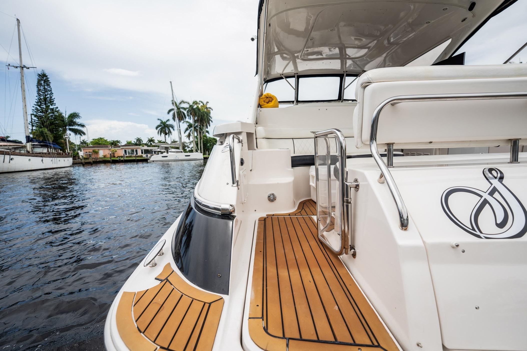2008 Regal Commodore 4460 yacht with teak deck, docked by waterfront homes.