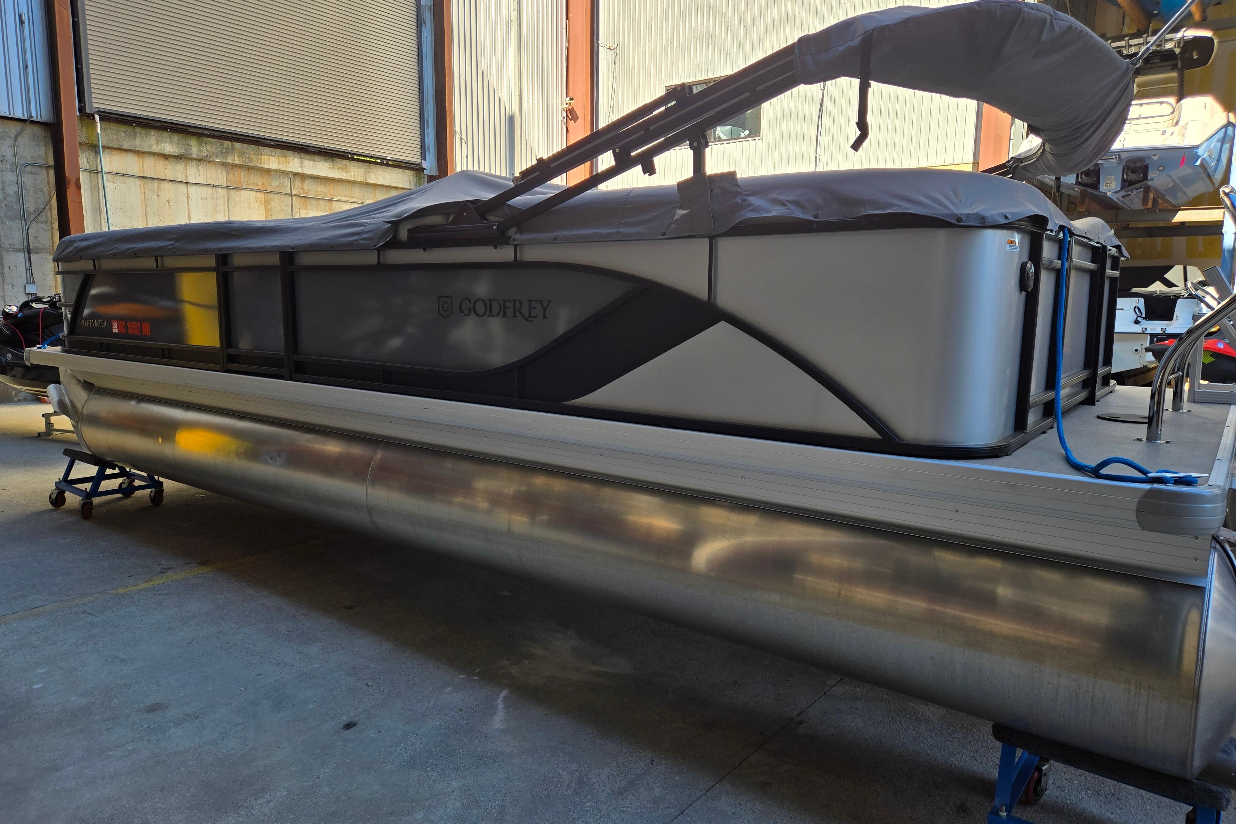 2024 Godfrey Sweetwater 2486 SB pontoon boat in storage, covered and secured.
